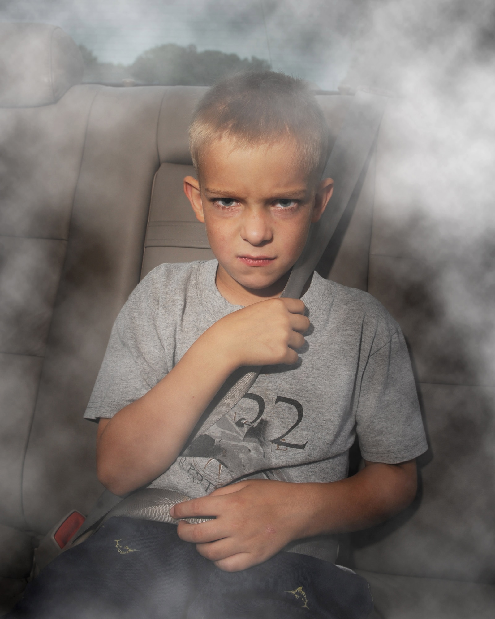 Ryan Glenn, son of Tech. Sgt. Johnnie Glenn, 53rd Airlift Squadron medical technician, depicts a child becoming angry by breathing second-hand smoke April 17 created by the driver of the family car.  The United States Environmental Protection Agency states on their Website, www.epa.gov/smokefree, second-hand smoke can cause serious health risks in children like increased asthma attacks and severity of symptoms, lower-lung respiratory tract infections and severely affects the developing lungs in young children.  (Photo illustration by Staff Sgt. Chad Chisholm)