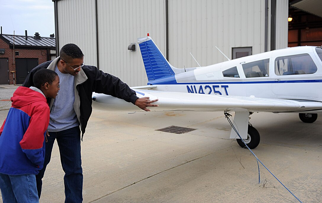 LANGLEY AIR FORCE BASE, Va. – Maj. Marcus Green, Air Combat Command A4 B-2 Weapons Load Team chief, explains principles of flight to his son Caleb, 11, at the Langley Aero Club 2010 Open House April 24. Guests enjoyed free food, demonstrations and orientation flights during the biannual event. (U.S. Air Force photo/Airman Rebecca Montez)
