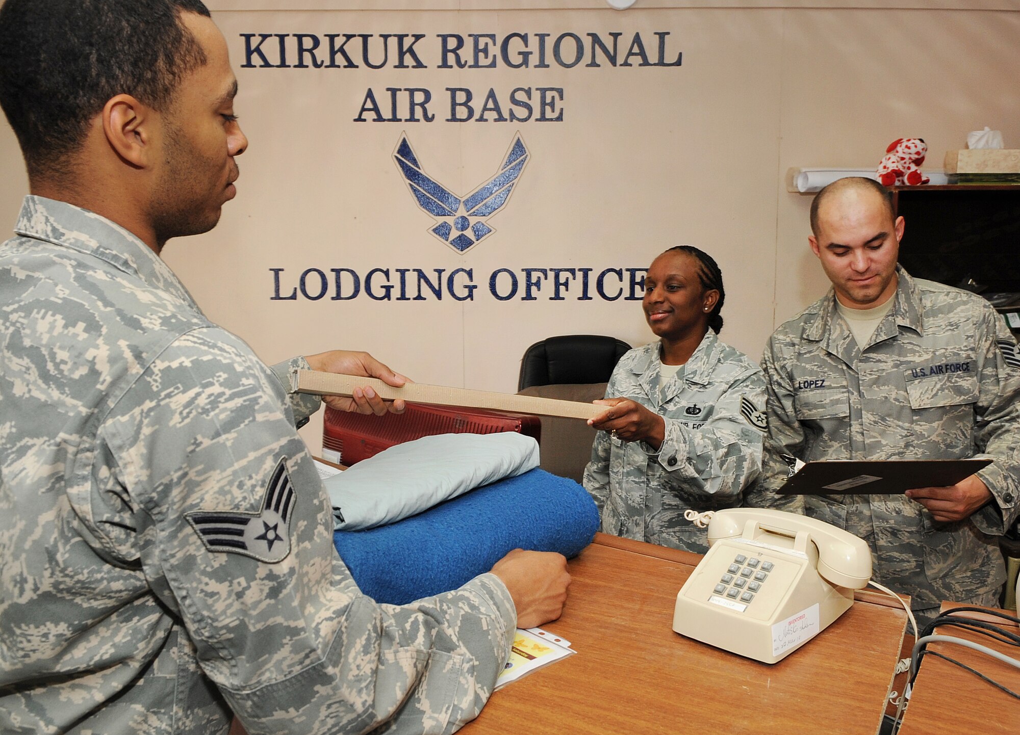Staff Sgt. Natika Adams and Tech. Sgt. Sebastian Lopez, 506th Expeditionary Force Support Squadron lodging staff, hand out supplies to a customer on Kirkuk Regional Air Base, Iraq on April 27, 2010.  The lodging staff provides basic essentials, including clean linen, beds, wall lockers, light bulbs, smoke detectors and cleaning products to Air Force members, Air Force and Army transient personnel, and contractors. (U.S. Air Force photo/Staff Sgt. Tabitha Kuykendall/Released)	