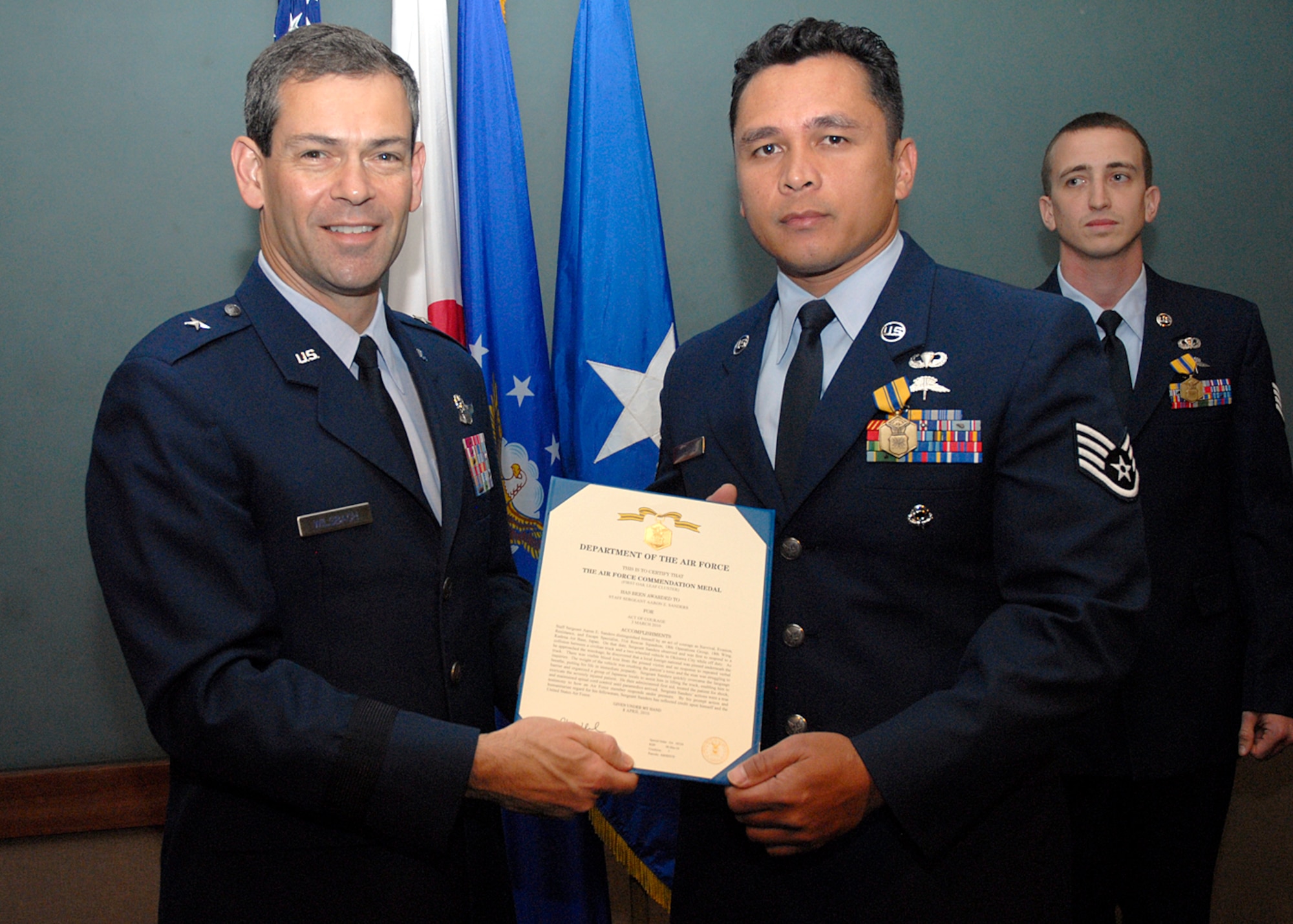 Staff Sgt. Abraham Forehand  stands next to Brig. Gen. Ken Wilsbach, 18th Wing commander, after receiving the Air Force Commendation Medal for an act of courage April 26. Sergeant Sanders and Staff Sgt. Aaron Sanders, from the 353rd Special Operations Group, both received medals for pulling a man pinned under an automobile after an off-base accident March 3. (U.S. Air Force photo / Airman 1st Class Jarvie Wallace)