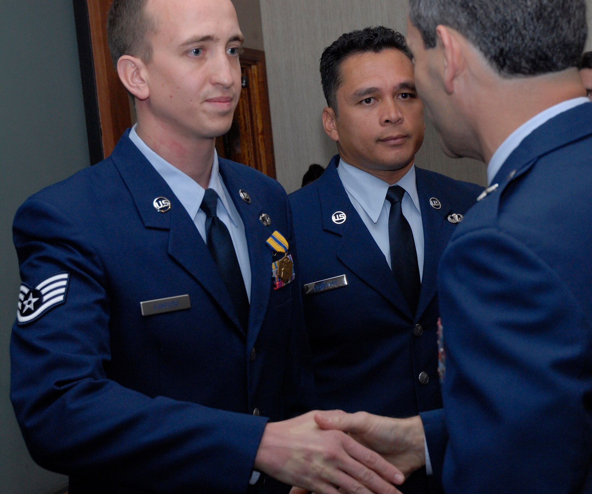 Staff Sgt. Aaron Sanders shakes hands with Brig. Gen. Ken Wilsbach, 18th Wing commander, after receiving the Air Force Commendation Medal for an act of courage April 26. Sergeant Sanders and Staff Sgt. Abraham Forehand (right), from the 353rd Special Operations Group, both received medals for pulling a man pinned under an automobile after an off-base accident March 3. (U.S. Air Force photo / Airman 1st Class Jarvie Wallace)