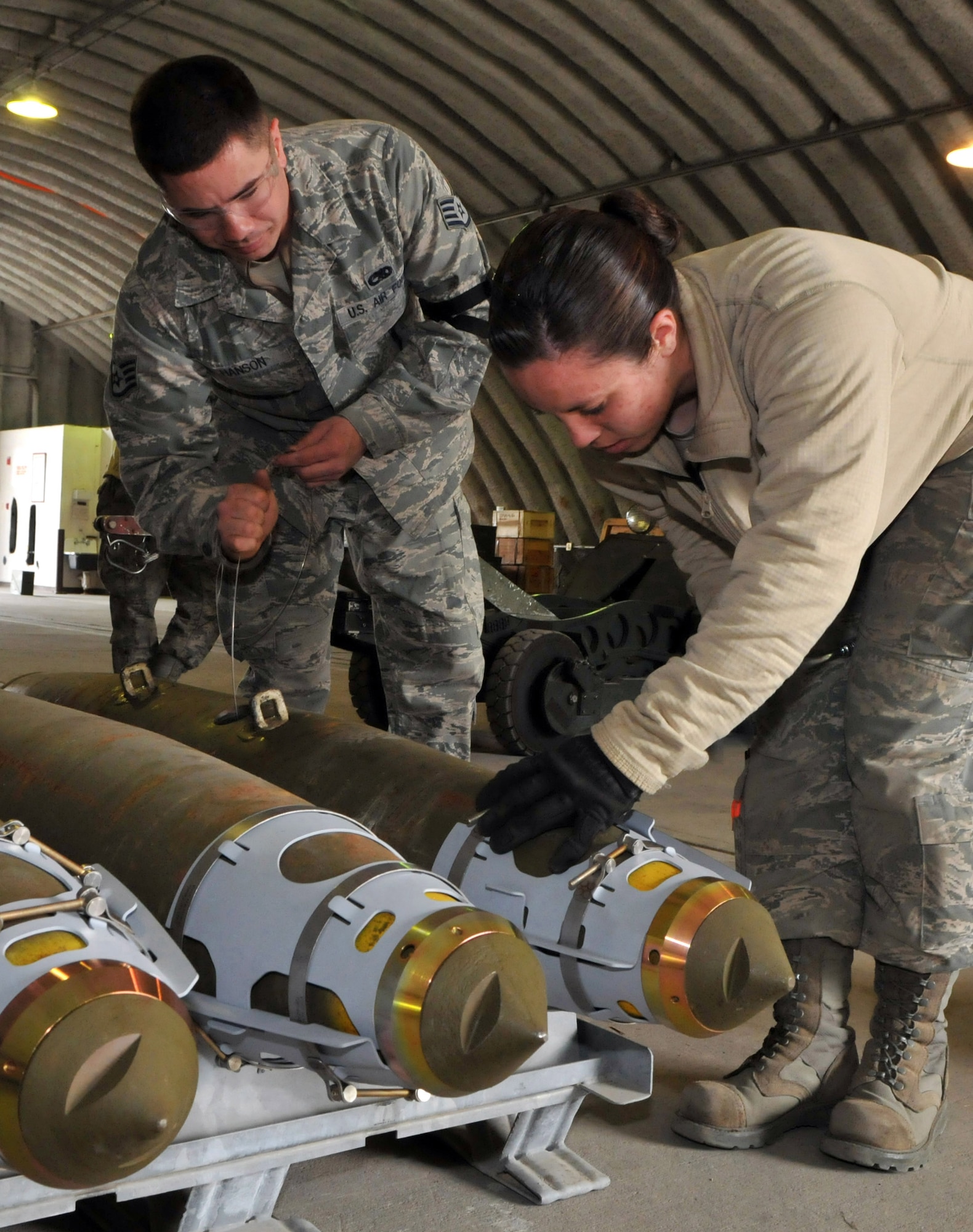 Staff Sgt. Joey Hanson, conventional maintenance crewchief, works on an initiator, while Airman 1st Class Amber Stepan, conventional maintenance crewmember, tightens a strake on a Joint Direct Attack Munition GBU-38 during Red Flag-Alaska at Eielson Air Force Base, Alaska, April 16. The initiator helps the bomb explode upon impact, and the strake gives stabilization and lift to the bomb in flight. Both Airmen are deployed from the 8th Maintenance Squadron, Kunsan Air Base, Republic of Korea. (U.S. Air Force photo/Capt. Shannon Collins)