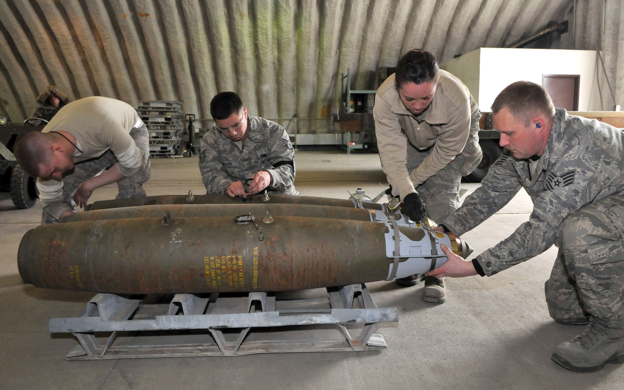 Airman Jacob Sherwood, precision guided munitions crewmember, inserts a fuse, Staff Sgt. Joey Hanson, conventional maintenance crewchief, connects the fuse to the initiator, Airman 1st Class Amber Stepan, conventional maintenance crewmember, uses a speed handle to tighten down a strake as Tech. Sgt. Alan Bold, conventional maintenance production superintendent, aligns the strake with the suspension lugs on a Joint Direct Attack Munition GBU-38 during Red Flag-Alaska at Eielson Air Force Base, Alaska, April 16. The Airmen are deployed from the 8th Maintenance Squadron, Kunsan Air Base, Republic of Korea. (U.S. Air Force photo/Capt. Shannon Collins)