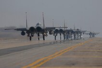 KUNSAN AIR BASE, Republic of Korea -- F-15E Strike Eagles  and an F-16 Fighting Falcon taxi down the runway with live ammunition here April 23. Wolf Pack participated in a no notice exercise testing the wing's ability to quickly and efficiently load live weapons and execute the operational mission. (U.S. Air Force photo/Staff Sgt. Darnell T. Cannady)
