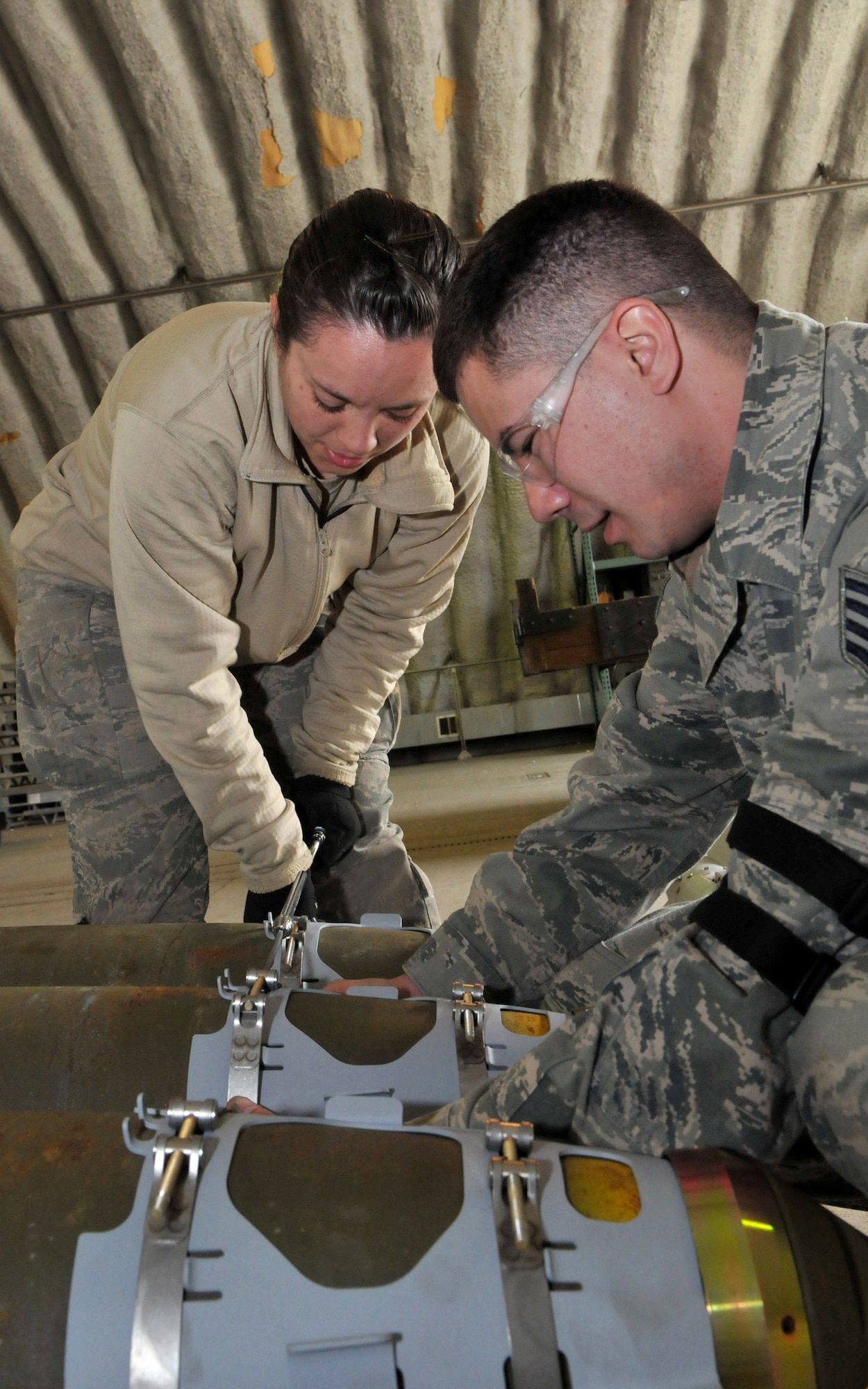 Airman 1st Class Amber Stepan, conventional maintenance crewmember, uses a speed handle to tighten down a strake as Staff Sgt. Joey Hanson, conventional maintenance crewchief, aligns the strake with the suspension lugs on a Joint Direct Attack Munition GBU-38 during Red Flag-Alaska at Eielson Air Force Base, Alaska, April 16. The strake gives the bomb stabilization and lift in flight. Both Airmen are deployed from the 8th Maintenance Squadron, Kunsan Air Base, Republic of Korea. (U.S. Air Force photo/Capt. Shannon Collins) 
