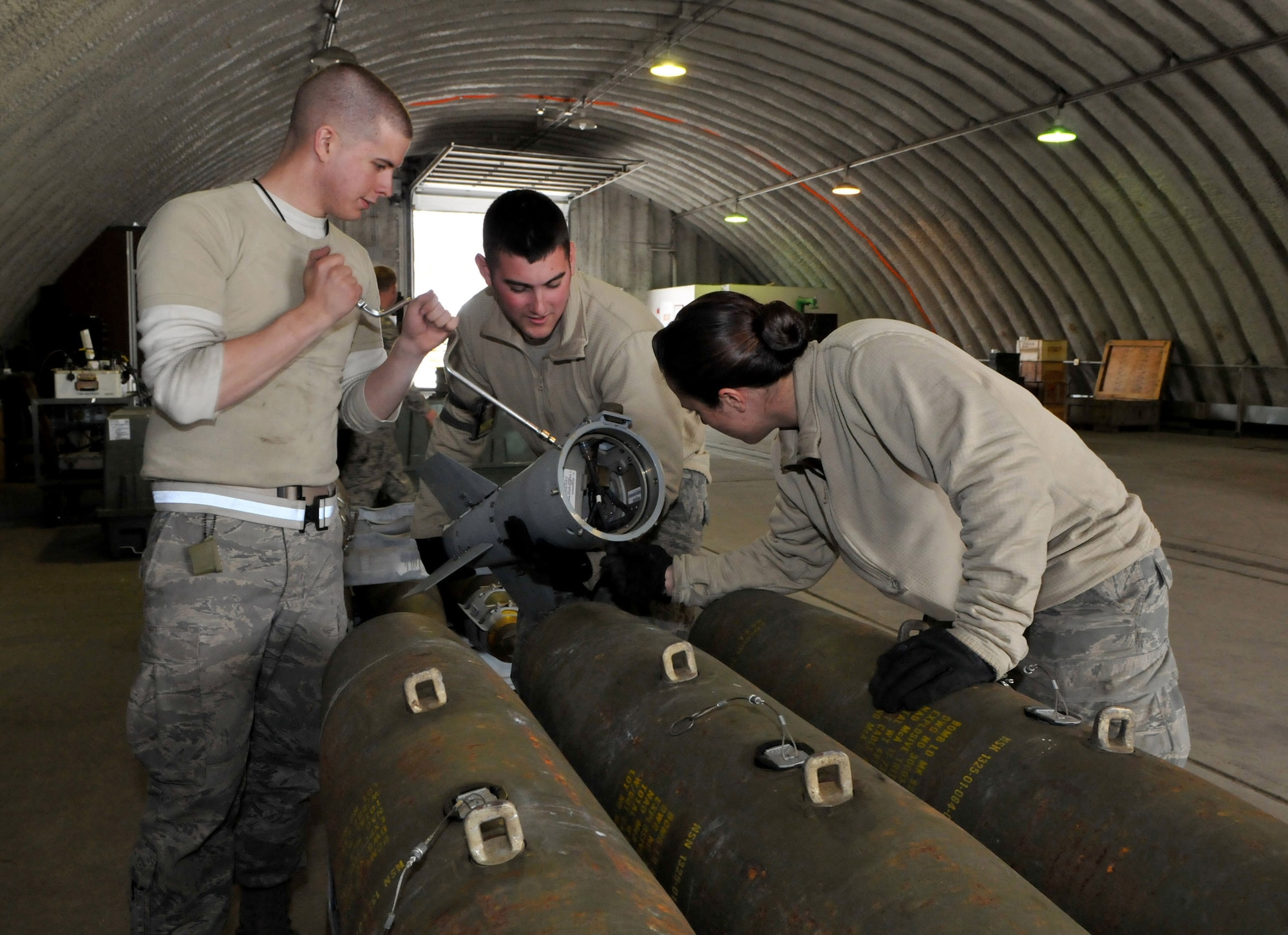 Airman Jacob Sherwood, precision guided munitions crewmember, Senior Airman Jake Thibodeau and Airman 1st Class Amber Stepan, conventional maintenance crewmembers, attach a tail kit onto a Joint Direct Attack Munition GBU-38 during Red Flag-Alaska at Eielson Air Force Base, Alaska, April 16. The tail kit provides GPS and electronic steering. The Airmen are deployed from the 8th Maintenance Squadron, Kunsan Air Base, Republic of Korea. (U.S. Air Force photo/Capt. Shannon Collins)