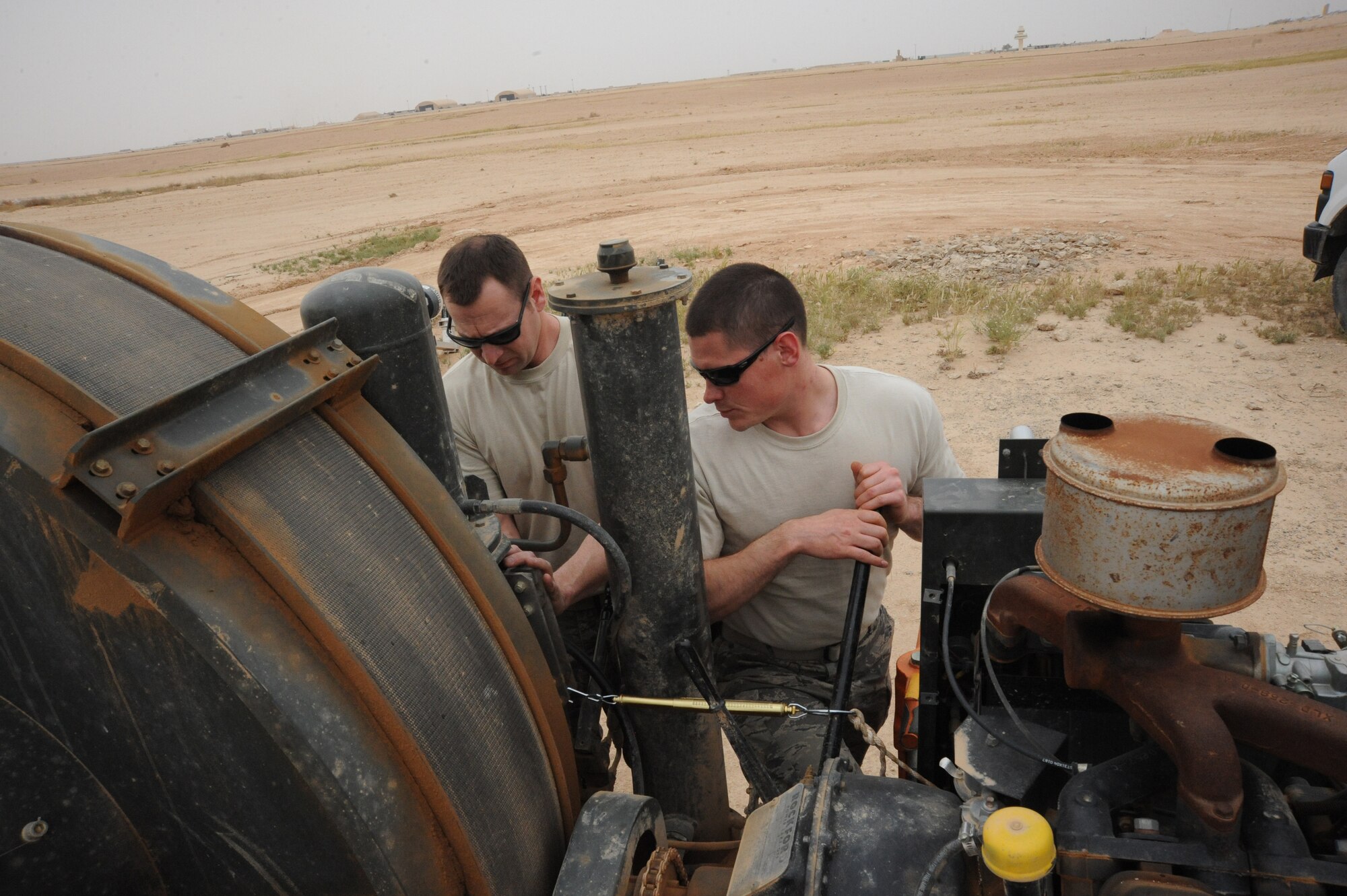 Air Force Tech. Sgt. Jeremey McLeod (left), barrier maintenance NCOIC,  and Airman 1st Class Anton Nashchechich, barrier maintenance technician, both from the 532nd Expeditionary Operations Support Squadron, perform their quarterly checks on the mobile aircraft arresting system barrier arresting kit-12, Al Asad, Iraq, April 17, 2010. Especially in a desert environment, it’s important to do weekly, monthly, and quarterly inspections to ensure the equipment is working properly at all times. (U.S. Air Force photo/Master Sgt. Trish Bunting/Released)