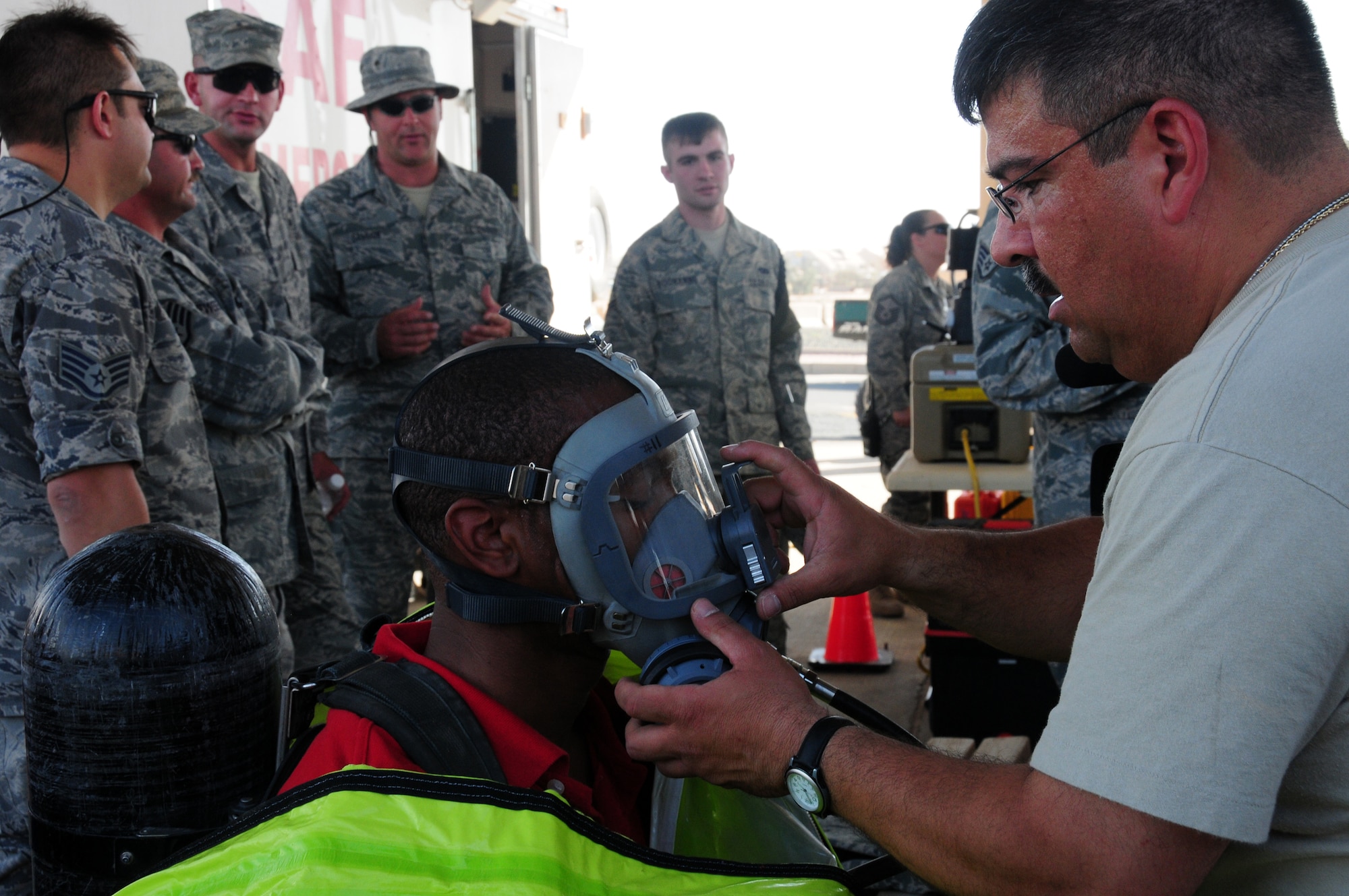 U.S. Air Force Senior Master Sgt. David Perez of the 386th Expeditionary Civil Engineer Squadron Emergency Management flight suits up Staff Sgt. Antwan Gilbert of the 386th Expeditionary Communications Squadron with a level A hazardous material suit April 24, 2010 at an air base in Southwest Asia. Dozens of Airmen participated in the event in which they got an upclose look at fire department, explosive ordnance disposal and emergency management response equipment and spoke with experts in each career field. (U.S. Air Force photo by Staff Sgt. Lakisha A. Croley/Released) 