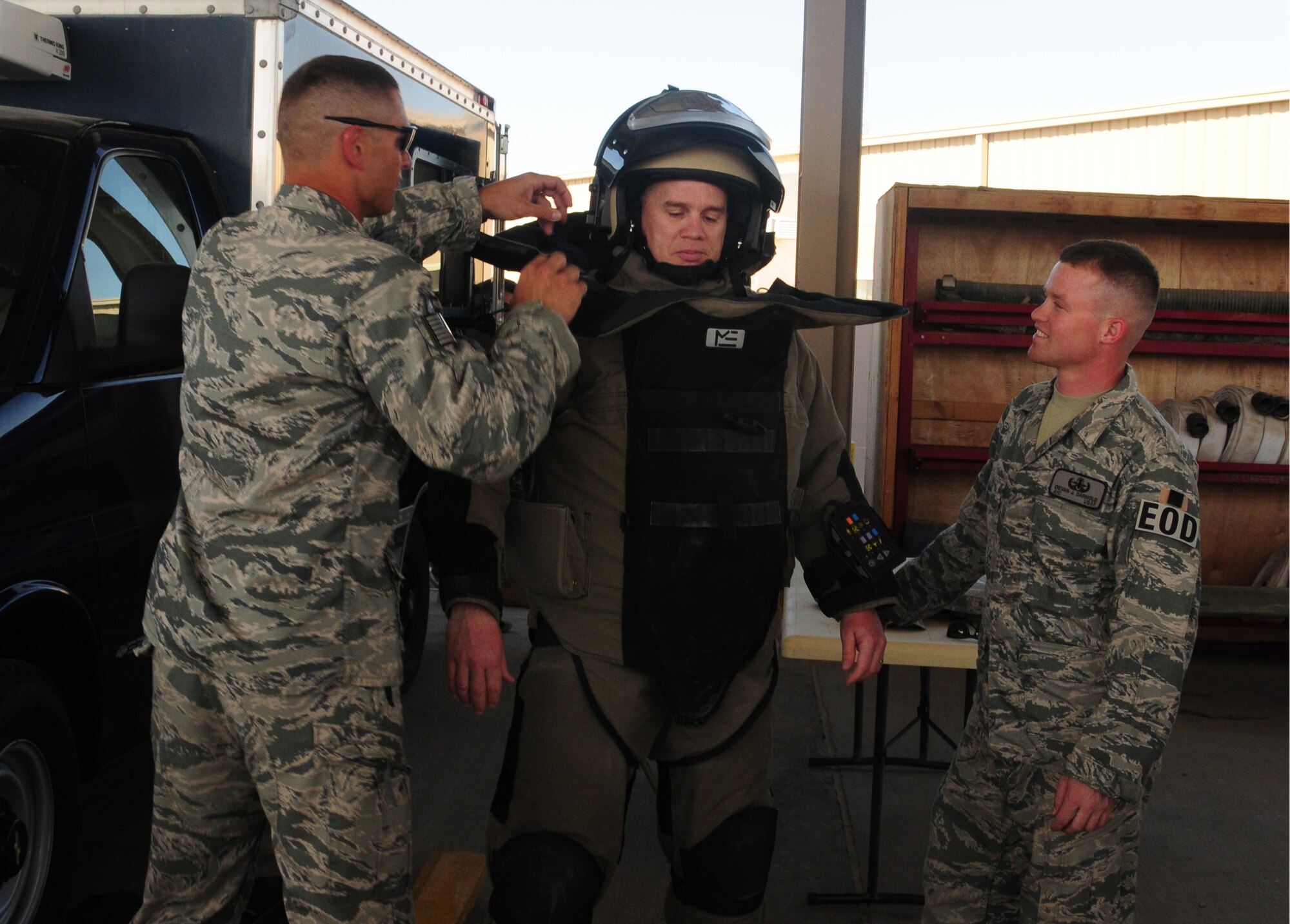 U.S. Air Force Staff Sgt. Dennis Barnhart, left, and Airman 1st Class Devon Darnold, both of the 386th Expeditionary Civil Engineer Squadron Explosive Ordnance Disposal flight, put a bomb suit on Chief Master Sgt. Michael McGillivary, 386th Expeditionary Mission Support Group superintendent, during the 386th ECES open house April 24, 2010 at an air base in Southwest Asia. Dozens of Airmen participated in the event in which they got an upclose look at fire department, explosive ordnance disposal and emergency management response equipment and spoke with experts in each career field. (U.S. Air Force photo by Staff Sgt. Lakisha A. Croley/Released)
