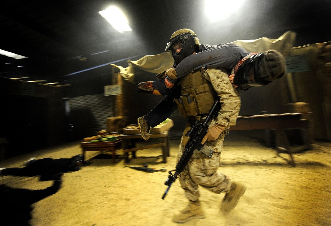 With Deputy Defense Secretary William J. Lynn III looking on, a U.S. Marine carries out a simulated wounded combatant to safety while at the combat simulation center on Camp Pendleton, Calif., April 26, 2010.
