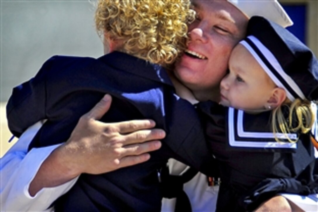 A sailor greets his children during a homecoming celebration for the USS Freedom in San Diego, April 23, 2010, after the ship's maiden deployment. The Freedom conducted numerous operations, including counter-illicit trafficking and port visits to Columbia, Panama and Mexico to support global maritime security.