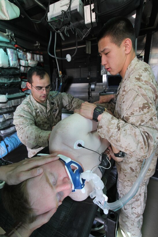 Medical personnel with Alpha Surgical Company, 1st Medical Battalion, 1st Marine Logistics Group (Forward), check a simulated patient’s back for wounds that require treatment inside a Mobile Trauma Bay at Camp Dwyer, Afghanistan, April 27. An MTB is an armored container on top of a Logistics Vehicle System Replacement, consisting of one doctor, one nurse and three corpsmen, that brings medical treatment closer to the battlefield.