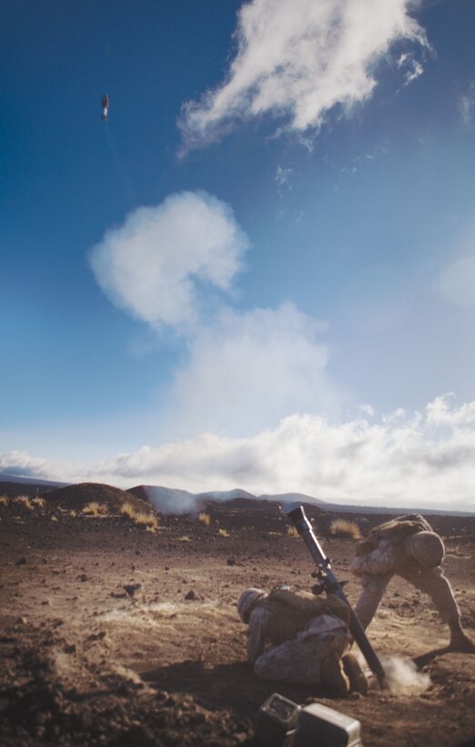 Lance Cpl. Ethan Eden and Pfc. Ethan P. Usborne send a round down range from their 81 mm mortar tube April 27 at the Pohakuloa Training Area.