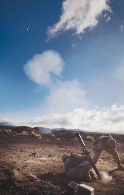 Lance Cpl. Ethan Eden and Pfc. Ethan P. Usborne send a round down range from their 81 mm mortar tube April 27 at the Pohakuloa Training Area.