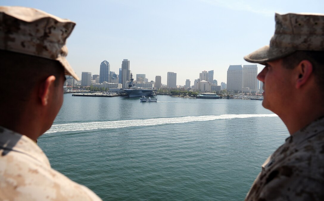 Sgt. Joseph Aranda, left, Marine Attack Squadron 311 ordnance noncommissioned officer in charge, and Cpl. Aaron McGuire, squadron ordnance technician, look out on San Diego from the deck of the USS Peleliu as the 15th Marine Expeditionary Unit returns from its final predeployment exercise April 27, 2010. Six AV-8B Harriers and approximately 80 squadron Marines left Yuma April 15 to participate in their third and final predeployment training evolution. The exercise, which began April 16 and is scheduled to end April 27, included the entire 15th MEU. The squadron is slated to deploy with the 15th MEU in May, during which it will conduct counter-piracy operations in the Pacific and Indian Oceans.