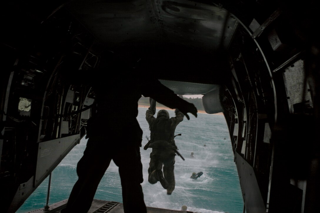 Marines participating in the Special Operations Training Group, III Marine Expeditionary Force Headquarters Group, III MEF, scout swimmer course jump out of a CH-46 Sea Knight flown by Marine Medium Helicopter Squadron 262, Marine Aircraft Group 36, 1st Marine Aircraft Wing, III MEF, while conducting helocast operations as part of the course’s final exercise April 28.