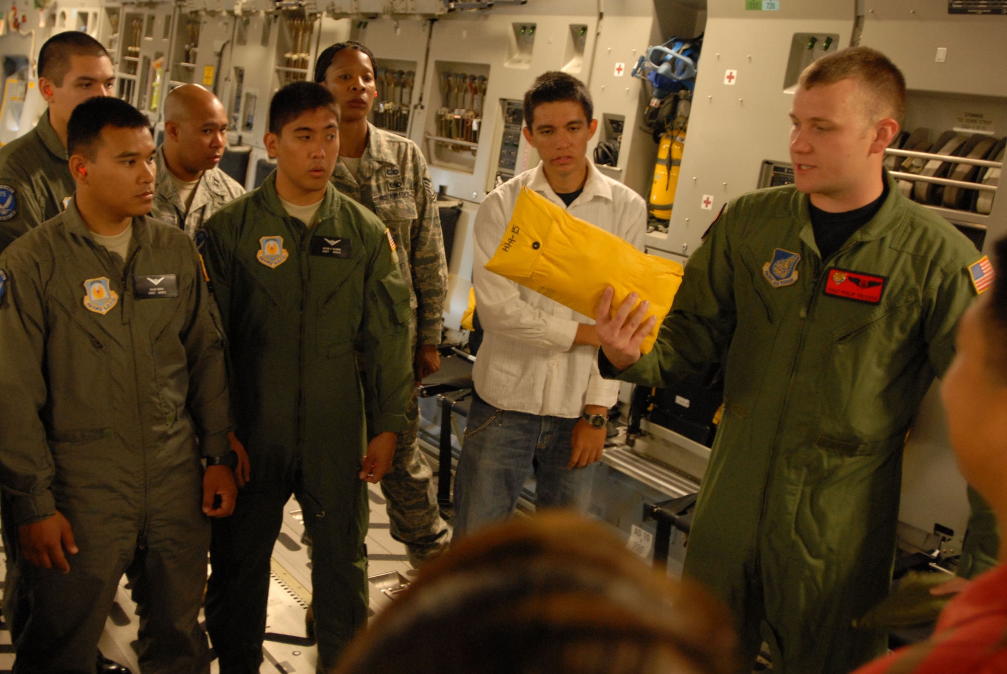 JOINT BASE PEARL HARBOR HICKAM, Hawaii - Army Reserves Officers' Training Corps and Air Force Reserves Officers' Training Corps cadets from the University of Hawaii Detachment 175th, are briefed by Staff Sgt. Phillip Valenta, 535th Airlift Squadron loadmaster, before riding on a C-17 Globemaster III during an incentive flight here, April 28. The annual incentive flight exposes cadets to active duty positions and allows them to get a first hand look at the pilot programs and other types of air force specialty codes. (U.S. Air Force photo/Senior Airman Gustavo Gonzalez)