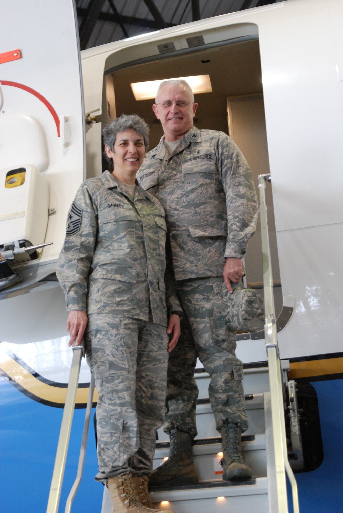 Command Chief Master Sgt. Sandra Santos and the 932nd Medical Group commander, Col. James Patterson, stand on the steps of a C-40C plane belonging to the 932nd Airlift Wing.  The Medical Group under the direction of Col. Patterson, takes care of physicals and immunizations for the operators of both the C-9C and C-40C planes.  (U.S. Air Force photo/Maj. Stan Paregien)