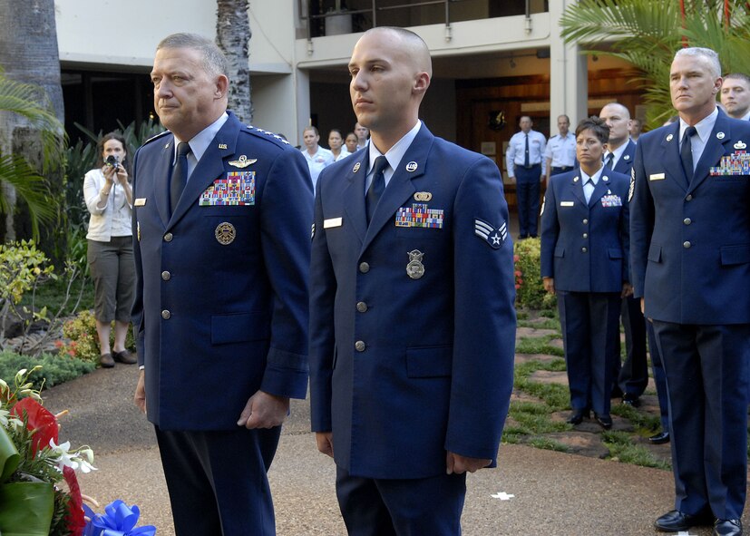 Gen. Gary North, Pacific Air Forces commander, and SrA David K.P. Rivera, one of Pacific Air Forces Airmen of the year stand at attention, after laying a wreath at the Courtyard of Heroes, Headquarters Pacific Air Forces, Joint Base Pearl Harbor Hickam, Hawaii, April 26, 2010. General North, PACAF Command Chief Master Sergeant Brooke McLean and PACAF?s outstanding Airmen presided over the ceremony honoring those who died at Hickam Air Field, Dec. 7, 1941. (U.S.  Air Force photo/Tech. Sgt. Jerome S. Tayborn)