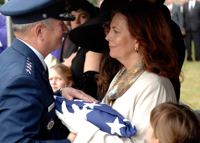 U.S. Air Force General Duncan  McNabb hands the American flag to Carmen Mikolajcik as three generations of Mikolajciks observe the rendering of honors after the funeral ceremony April 24, 2010, at the Cathedral of St. John the Baptist in Charleston, S.C. General McNabb is the U.S. Transportation Commander at Scott Air Force Base, Ill. and Mrs. Mikolajcik is the widow of U.S. Air Force Brig. Gen. Thomas R. Mikolajcik. (U.S. Air Force photo/Senior Airman Timothy Taylor)