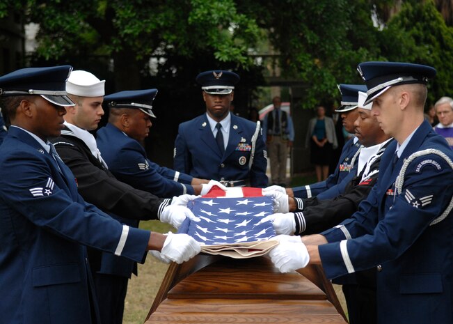 Members of the Joint Base Charleston Honor Guard fold U.S. Air Force Brig. Gen. Thomas R. Mikolajcik's American flag during the funeral ceremony April 24, 2010, at the Cathedral of St. John the Baptist in Charleston, S.C. The honor guard, composed of volunteers who are highly motivated, maintain exceptionally high standards of dress and appearance and show aptitude for ceremonial duty. (U.S. Air Force photo/Senior Airman Timothy Taylor)