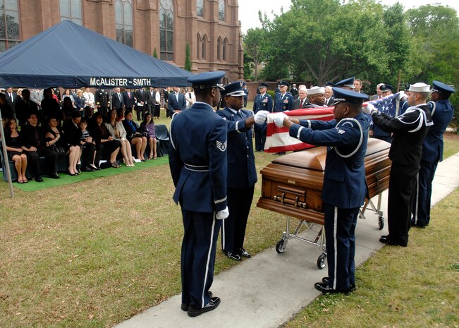 U.S. Air Force Brig. Gen. Thomas R. Mikolajcik's family watch as members from Joint Base Charleston Honor Guard fold the American flag to be given to the family in remembrance April 24, 2010, at the Cathedral of St. John the Baptist in Charleston, S.C. The general retired from the Air Force in 1996, but remained active with the Charleston Metro Chamber of Commerce. His contributions proved pivotal in the efforts to minimize base closures and job losses during Base Realignment and Closure in 2005. (U.S. Air Force photo/Senior Airman Timothy Taylor)