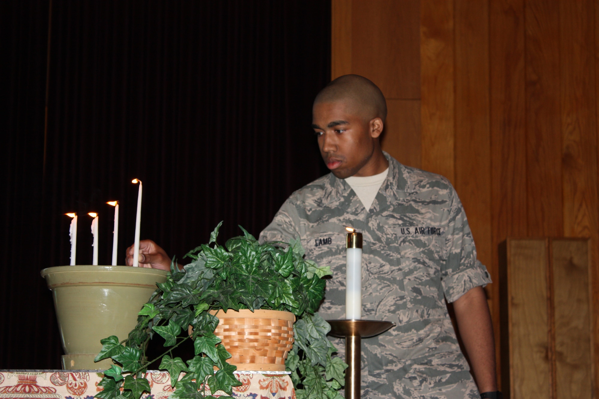 Airman 1st Class Marcus Lamb, 332nd Training Squadron, lights a candle after reading a prayer for deployed troops  during the National Prayer Event April 22 at Triangle Chapel.  The service focused on prayers for the nation.  Chief Master Sgt. Lonnie Slater, 81st Training Wing command chief, spoke on the military and the importance of the freedom of religion.  Sixteen students sang, played instruments and read prayers and poetry.  Chaplain (Capt.) Kenya Thomas, project leader, said about 85 people attended. The 81st Training Group chaplains and nonprior service students sponsored the event and members of the parish supplied desserts.  (U.S. Air Force photo by Airman John Kenyon)
