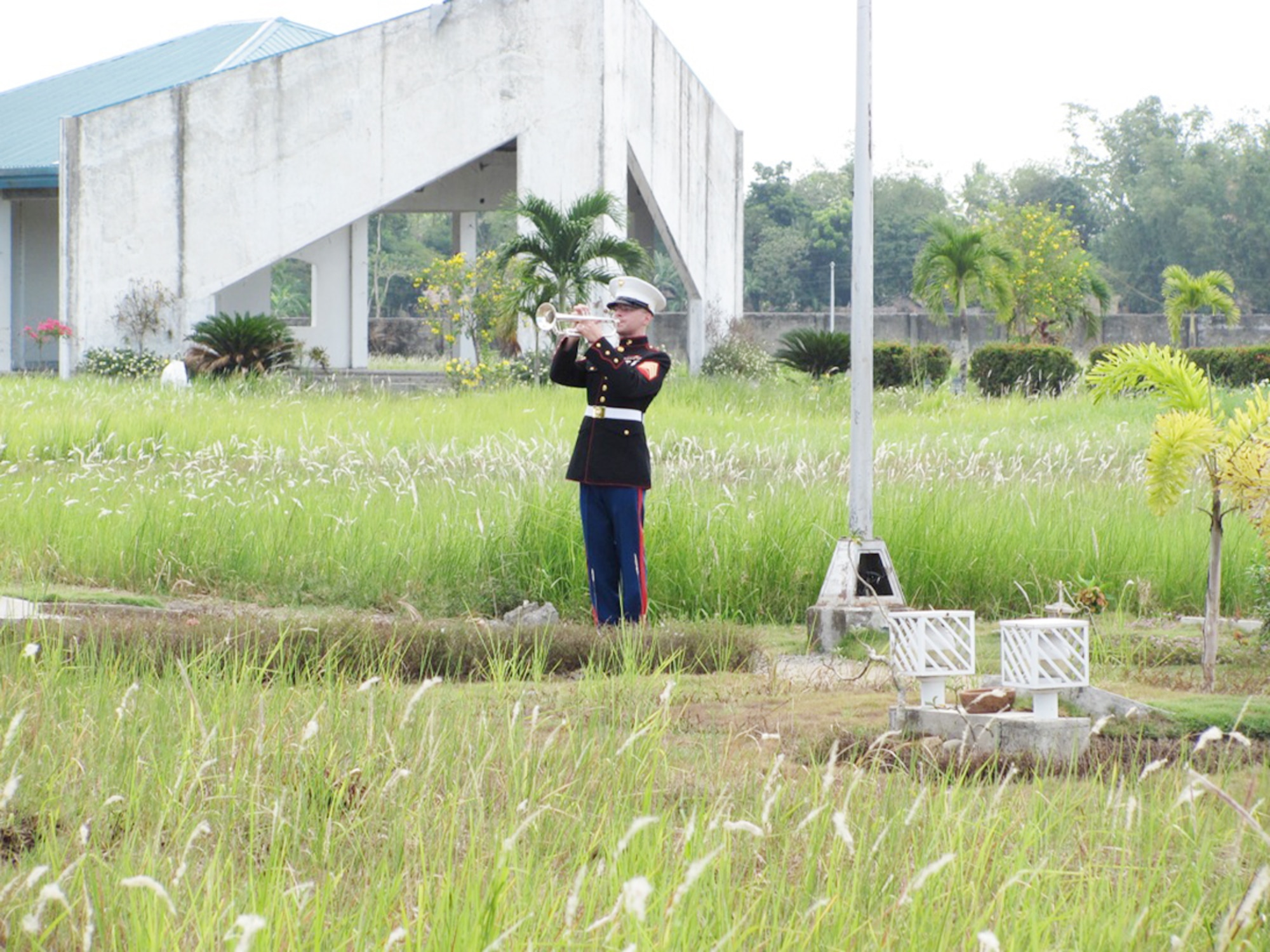 Marine Sgt. Aaron Wagners plays taps during the funeral for Tech. Sgt. Raymond Natividad who was buried April 27, 2010, in Bacolod, Philippines. Sergeant Wagners is a bugler from the 3rd Marine Band on Okinawa. (U.S. Air Force photo/Tech. Sgt. Brian Roberts)