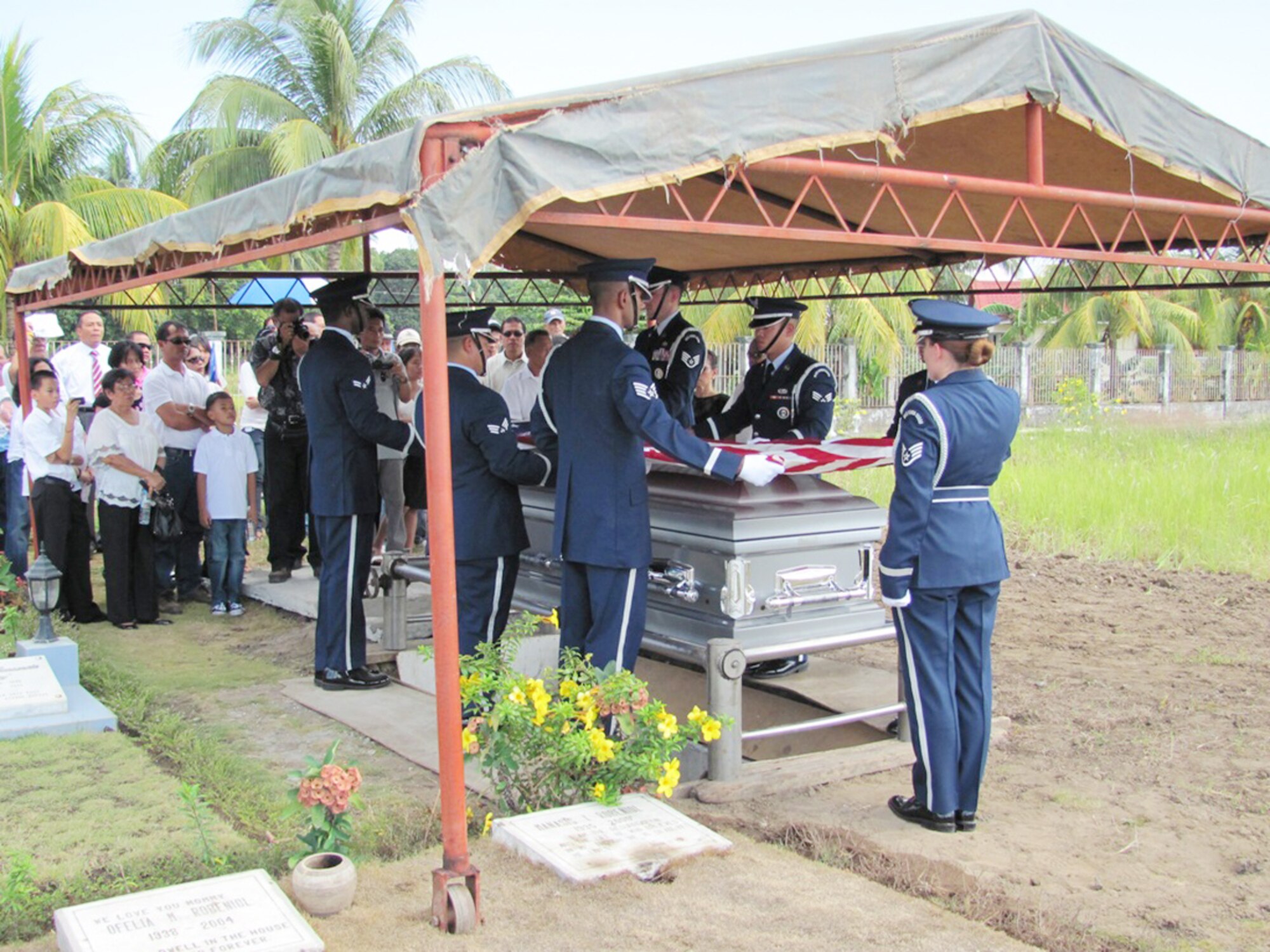 Staff Sgt. Lacey Brown (right) salutes as members of the Kadena Air Base Honor Guard fold the American flag during a funeral for Tech. Sgt. Raymond Natividad April 27, 2010, in Bacolod, Philippines. (U.S. Air Force photo/Tech. Sgt. Brian Roberts)