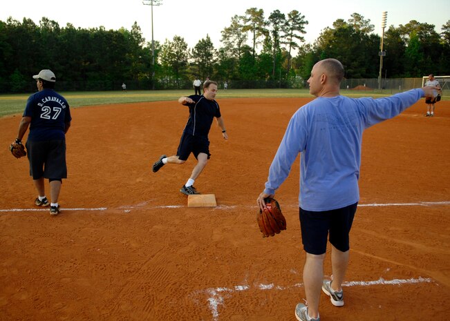 Tech. Sgt. Arrin Baker waves 1st Lt. David Gantt home putting the 701st down by one at the top of the last inning at the softball field April 23, 2010, on Joint Base Charleston, S.C. Sergeant Baker is a loadmaster for the 300th Airlift Squadron and Lieutenant Gantt is a pilot with the 701st Airlift Squadron. (U.S. Air Force photo/Senior Airman Timothy Taylor)