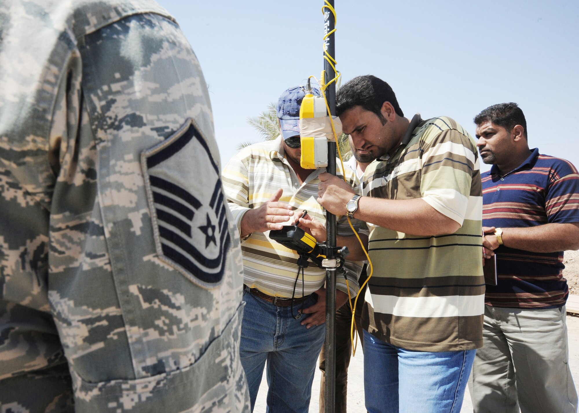 Air Force Master Sgt. Varoujan Garabedian stands by ready to assist the Iraqi field and engineering team as they learn how to input data into the global positioning station controller April 19, 2010, at Al Asad Air Base, Iraq. Sergeant Garabedian is an engineering assistant for 732nd Expeditionary Prime Beef Squadron. (U.S. Air Force photo/Master Sgt. Trish Bunting)