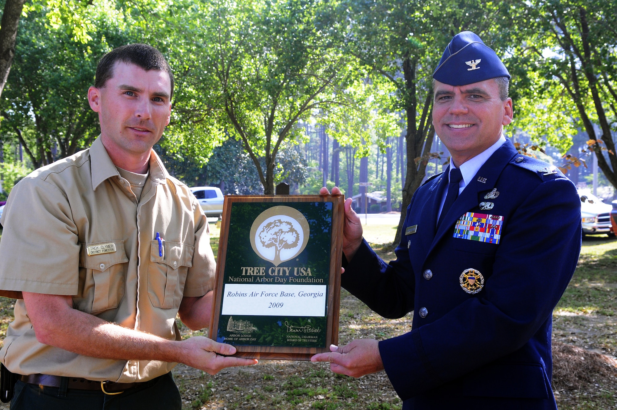 Forester Troy Clymer presents Col. David Southerland, 78th ABW vice commander, with a plaque designating Robins as a Tree City, USA. U. S. Air Force photo by Sue Sapp