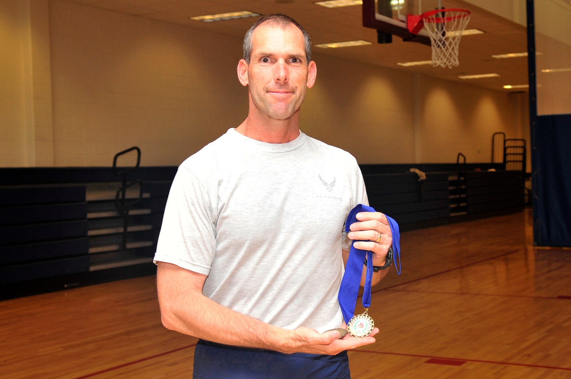 BUCKLEY AIR FORCE BASE, Colo. -- Todd Kennedy receives an award for his excellent performance in the Push-up / Sit-up competition here April 21. Kennedy won in his age group for both exercises with 74 push-ups and 55 sit-ups. (U.S. Air Force photo by Airman 1st Class Manisha Vasquez)