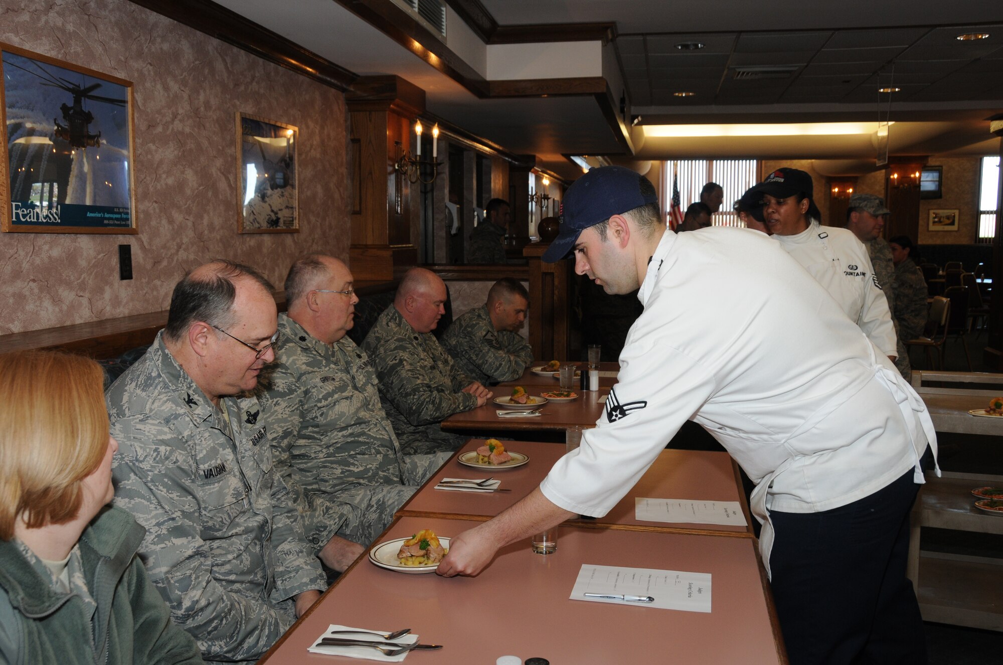 Senior Airman David Siegel of Team B serves Col. Timothy Vaughan their creation of pork tenderloin with rum-molasses glaze and grilled pineapple-jalape'o sauce served with fried green beans. (U.S. Air Force photo/Staff Sgt. Peter Dean)