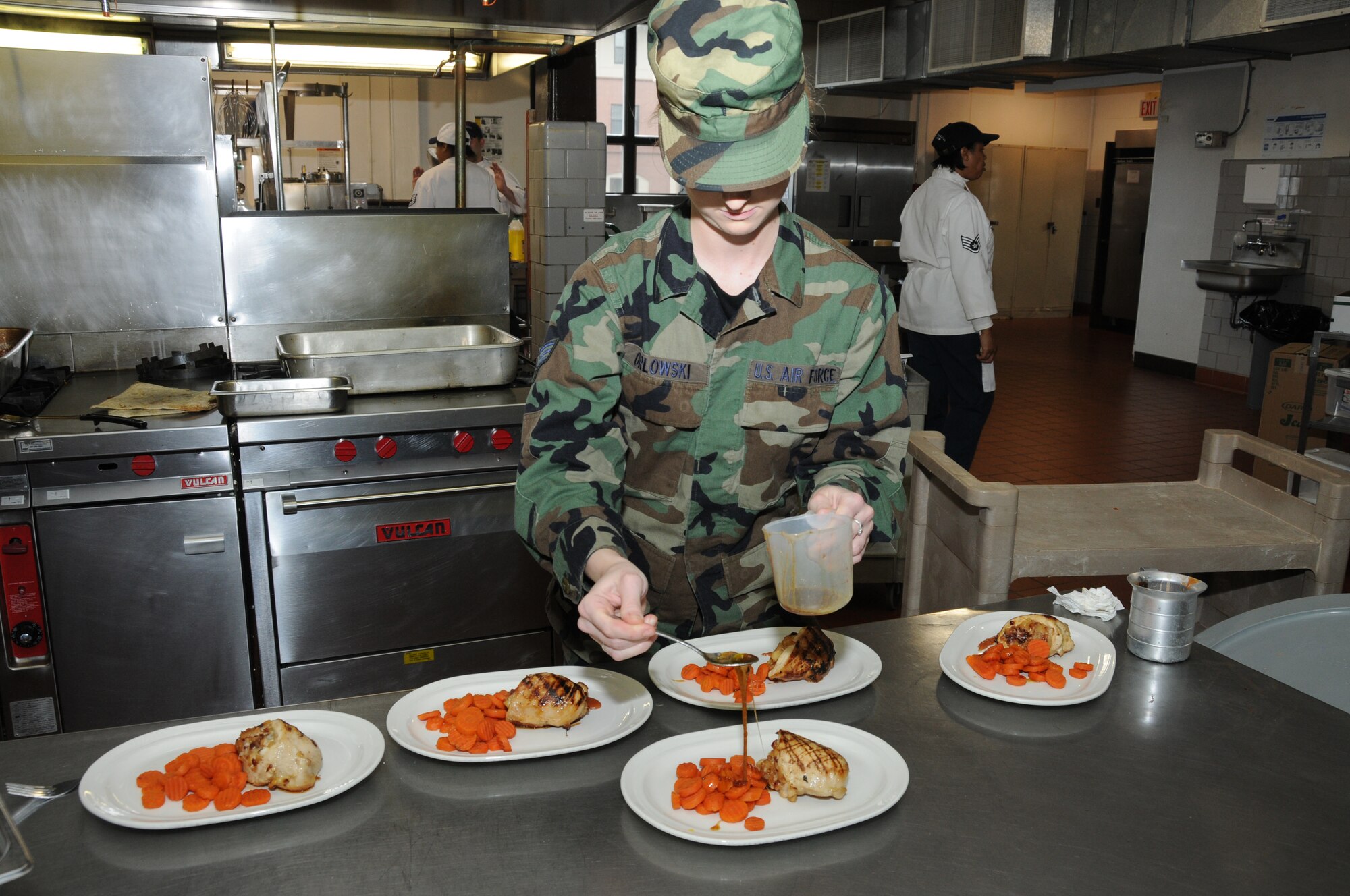 Senior Airmen Evelyn Orlowski from Team A prepares the plate for the judges. Team A's meal was Caramelized apple stuffed chicken breast with fontina and bing cherries served with glazed carrots. (U.S. Air Force photo/Staff Sgt. Peter Dean)