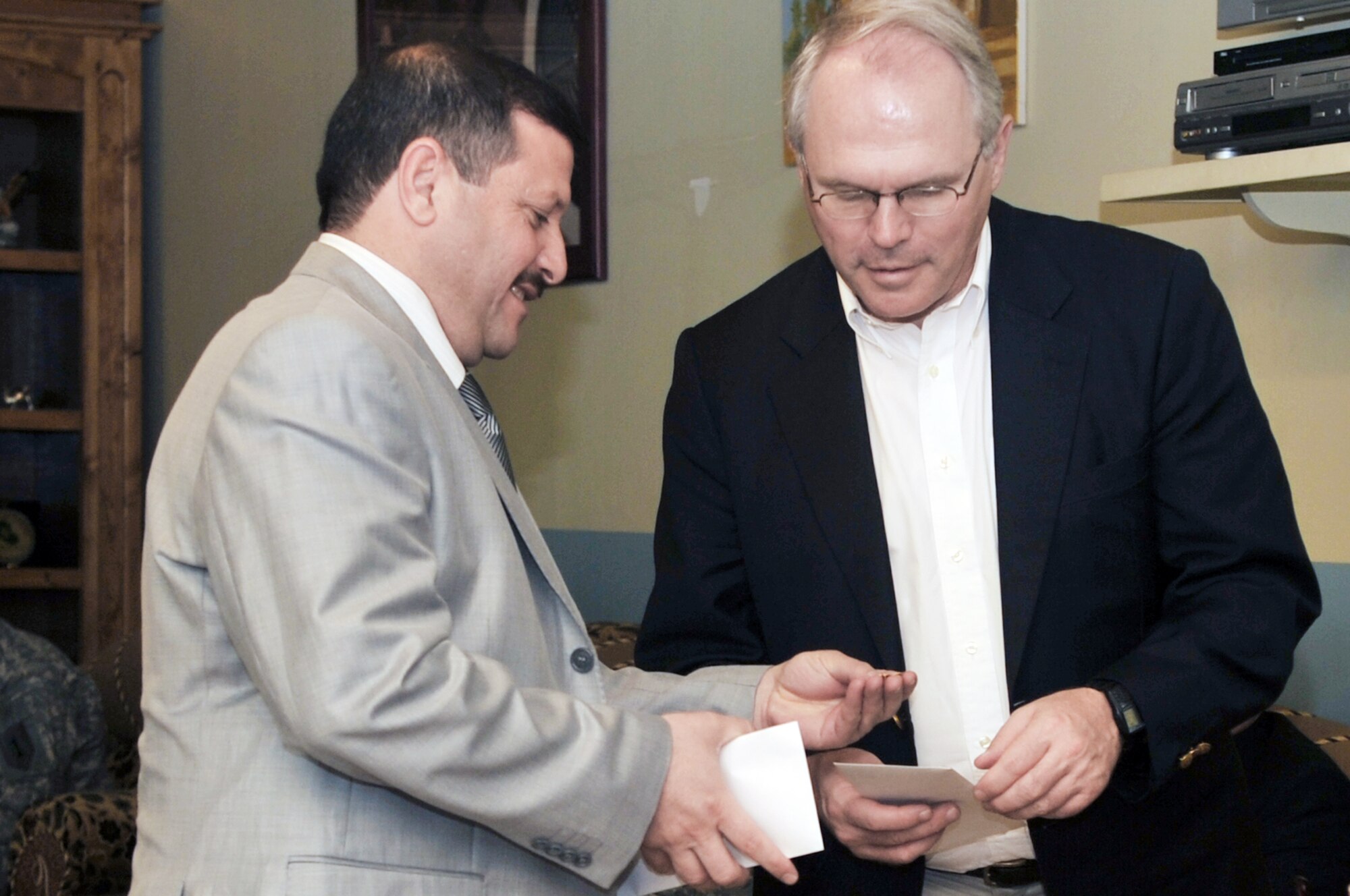 A local national shows his appreciation to U.S. Ambassador to Iraq Christopher Hill by giving him a pin during his visit April 23, 2010, to the provincial reconstruction team at Joint Base Balad, Iraq. (U.S. Air Force photo/Senior Airman Brittany Y. Bateman) 