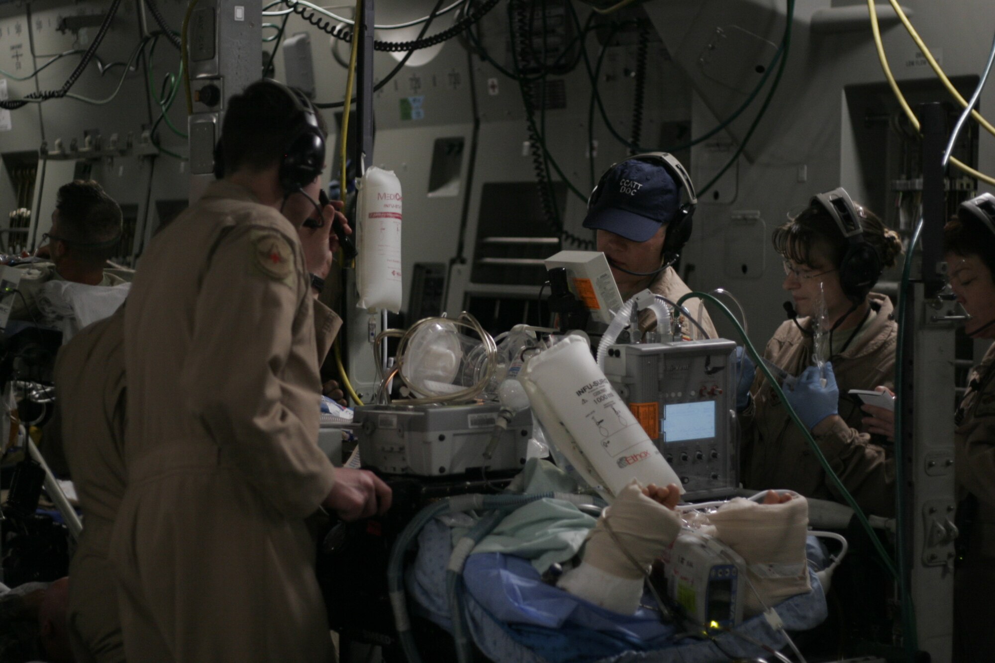 BAGRAM AIR FIELD, Afghanistan -- Members of a Critical Care Air Transport Team tend to a critically ill patient aboard a C-17 Globemaster III en route to Landstuhl Regional Medical Center in Germany from Bagram Airfield, Afghanistan.  A CCATT is a highly-specialized medical team made up of three members: a critical care physician and nurse, and a respiratory therapist, who operate an intensive care unit in an aircraft during flight. (U.S. Air Force photo by 2nd Lt. Daniel Riley)