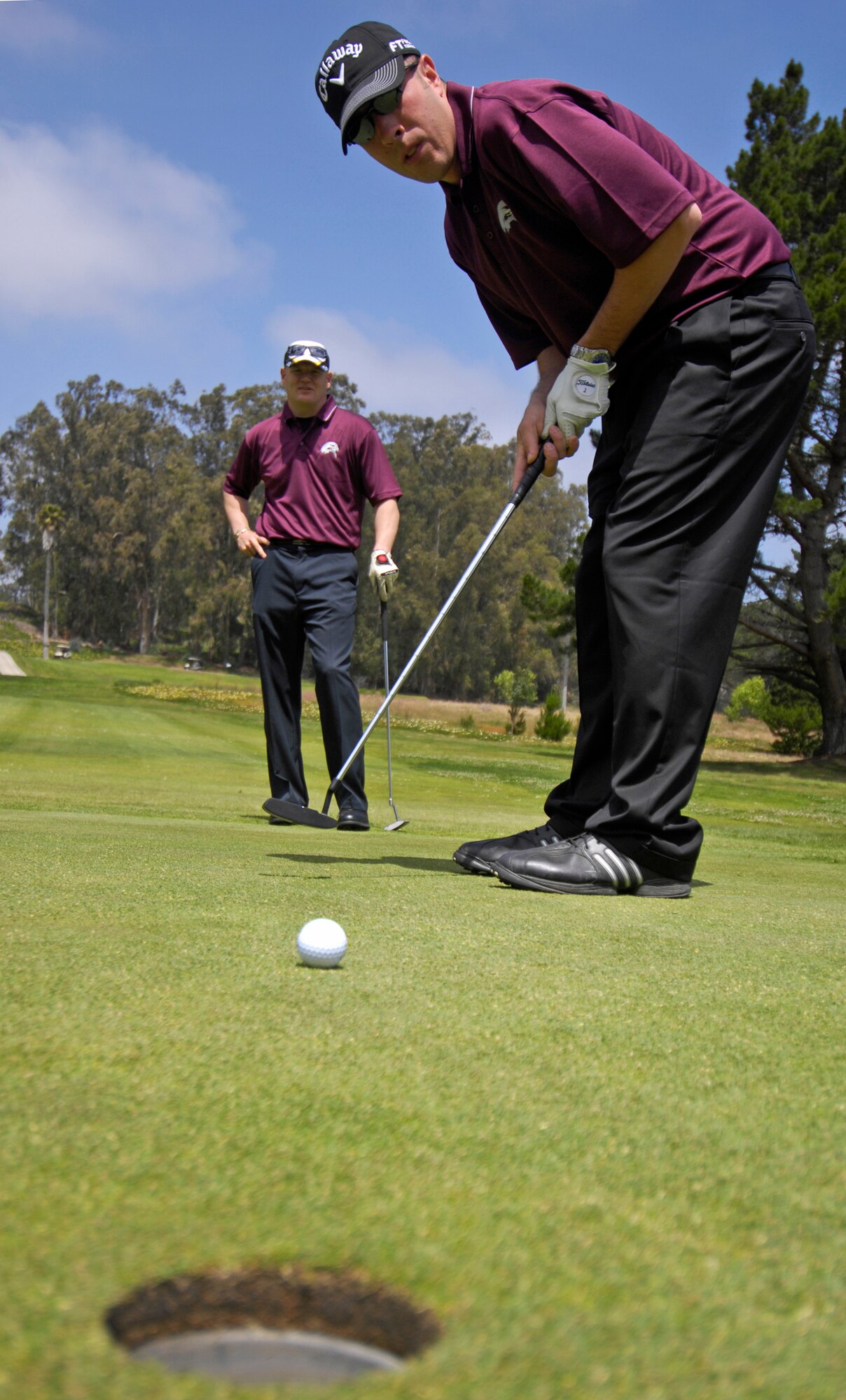VANDENBERG AIR FORCE BASE, Calif. -- Staff Sgt. Mike Messina, from the 30th Security Forces Squadron, gently putts the golf ball toward the hole, as one of his team members watches, during the Guardian Challenge golf tournament at  the Marshallia Ranch Golf Course here Friday, April 23, 2010. (U.S. Air Force photo/Airman 1st Class Andrew Lee)