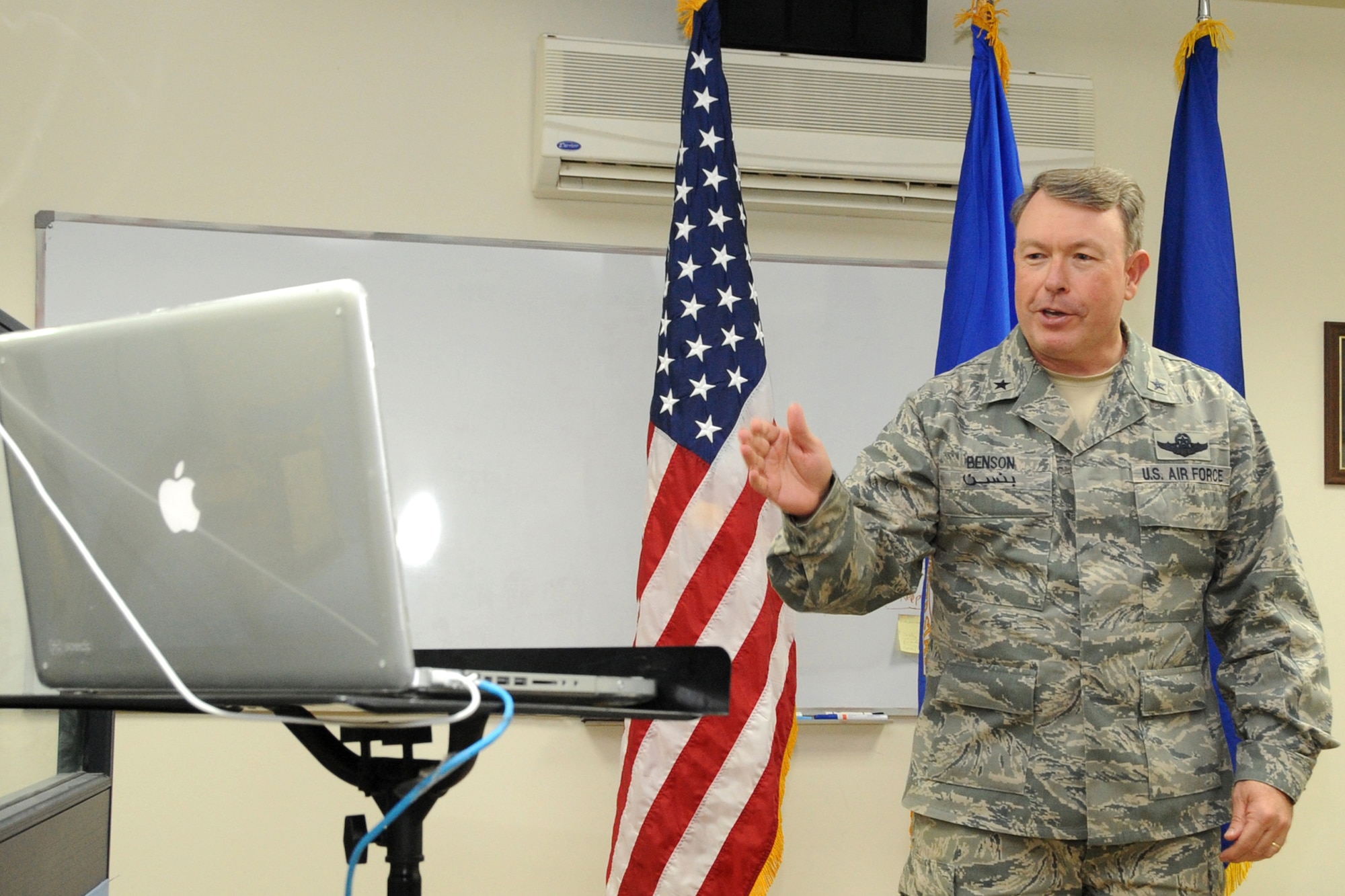 Brig. Gen. Bryan J. Benson, commander, 380th Air Expeditionary Wing, speaks to Maj. Brian Vance's family via a laptop computer screen during the major's promotion ceremony March 31, 2010, at an undisclosed base in Southwest Asia. The laptop allowed the Vance family to attend the ceremony virtually through a Voice over Internet Protocol or VoIP connection. While Major Vance was deployed his family was at home in Virginia. (U.S. Air Force photo/Senior Airman Jenifer H. Calhoun/Released)