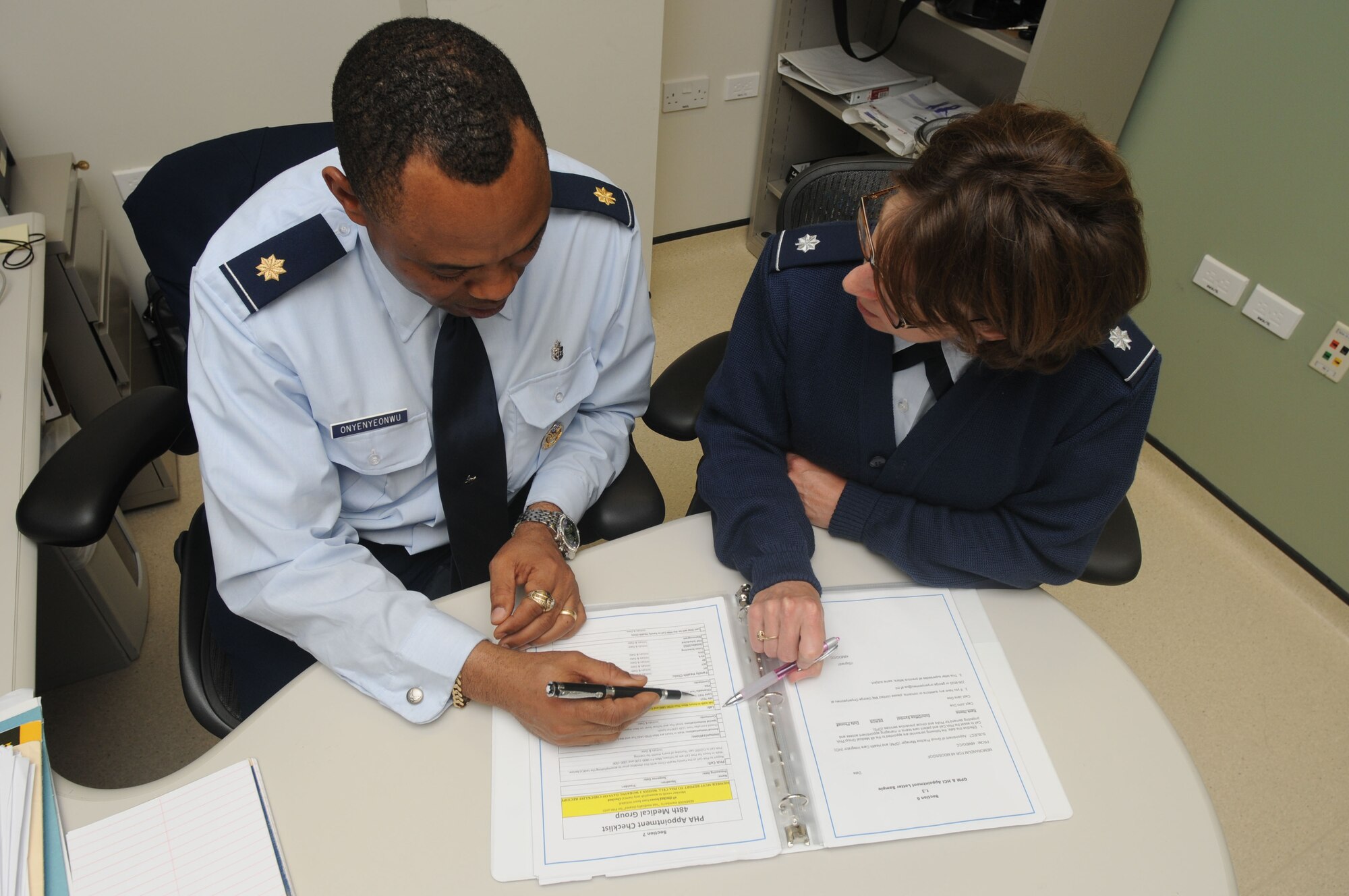 Maj. George Onyenyeonwu, 48th Medical Group Senior Group Practice Manager, reviews the preventive health assessment appointment checklist with Lt. Col. Marcia Potter, 48th Medical Group Family Health Clinic commander, at RAF Lakenheath on April 19. The PHA appointment checklist was developed for use specifically for the 48th MDG to aid patients in completing their PHA more efficiently. (U.S. Air Force photo by Airman 1st Class Lausanne Morgan)