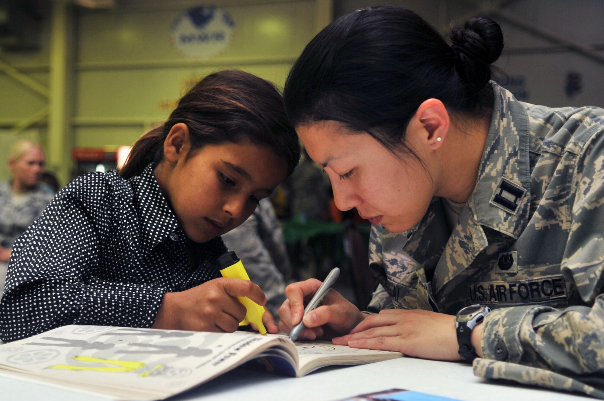 Capt. Erin Lai, a judge advocate with the 332nd Air Expeditionary Wing Staff, colors a picture with an Iraqi girl during Iraqi Kids Day at Joint Base Balad, Iraq, April 24, 2010. This was the first Iraqi Kids Day of 2010 and it serves as part of the ongoing base effort to positively engage the local populace.  Thirty-four children from a local orphanage were bussed onto base to play games, share culture and to have a day of fun. (U.S. Air Force photo by Senior Airman Brittany Y. Bateman/Released)