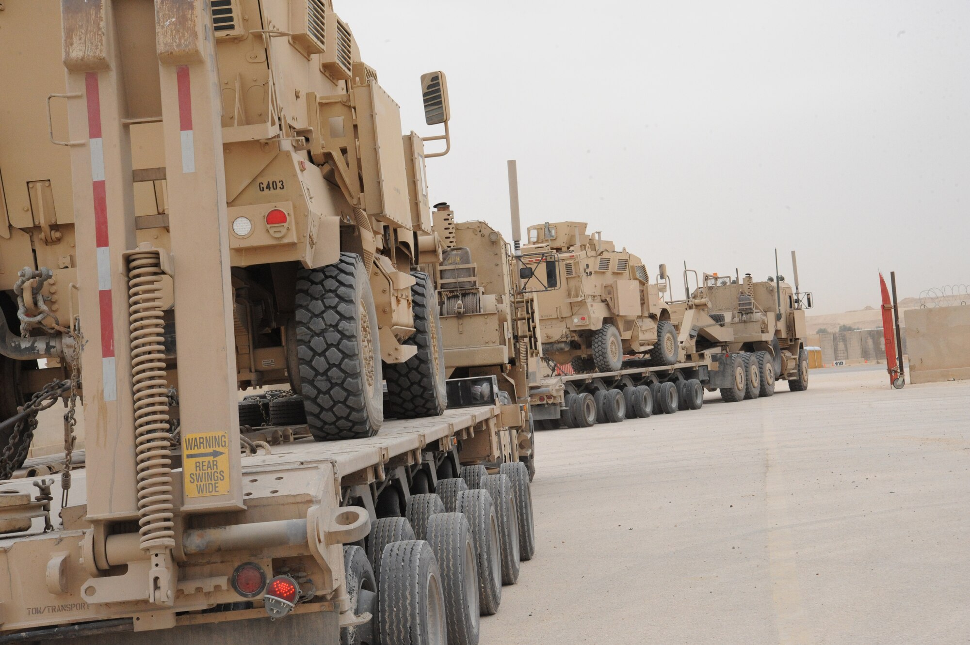 Two Mine Resistant Ambush Protected vehicles are loaded onto eighteen wheelers whose final destination is Arifjan, Kuwait, as part of the Operations Iraqi Freedom drawdown, Al Asad Air Base, Iraq, April 17, 2010. The mission of the Redistribution Property Assistance Team is to meet the presidential intent to facilitate the expedient turn-in of all excess Class VII Theater Provided Equipment, improve property accountability of retrograding equipment from Iraq and enable asset visibility of the received equipment during transit to Source of Repair or Operation Enduring Freedom.(U.S. Air Force photo/Master Sgt. Trish Bunting/Released)