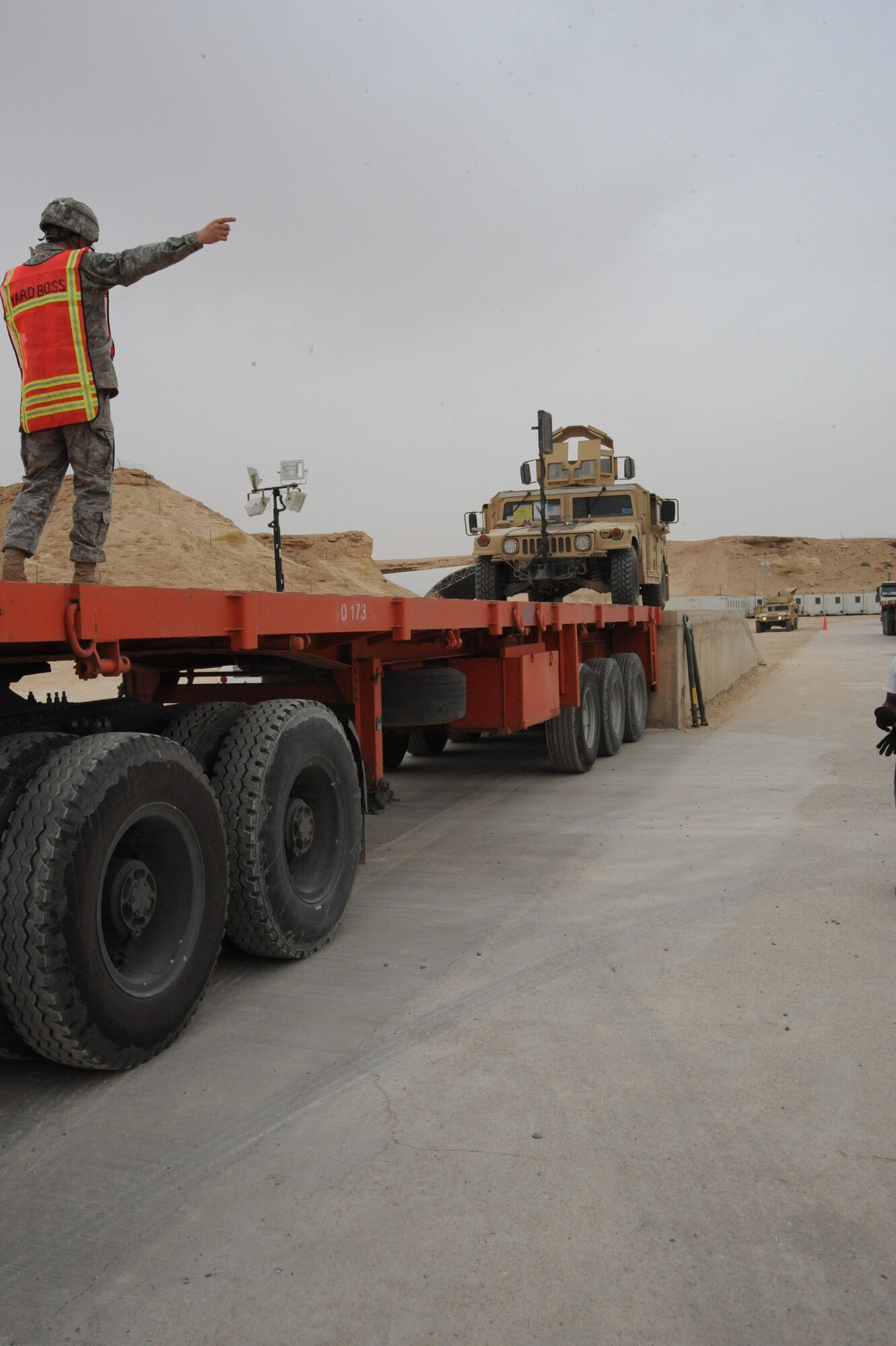 Air Force Staff Sgt. Matthew Burns, yard boss, 2/402nd Army Field Support Brigade, directs a humvee onto an eighteen wheeler whose final destination is Arifjan, Kuwait, as part of the drawdown, Al Asad Air Base, Iraq, April 17, 2010. The mission of the 2nd BN, 402 AFSB Redistribution Property Assistance Team is to meet the presidential intent to facilitate the expedient turn-in of all excess Class VII Theater Provided Equipment, improve property accountability of retrograding equipment from Iraq and enable asset visibility of the received equipment during transit to Source of Repair or Operation Enduring Freedom. (U.S. Air Force photo/Master Sgt. Trish Bunting/Released)