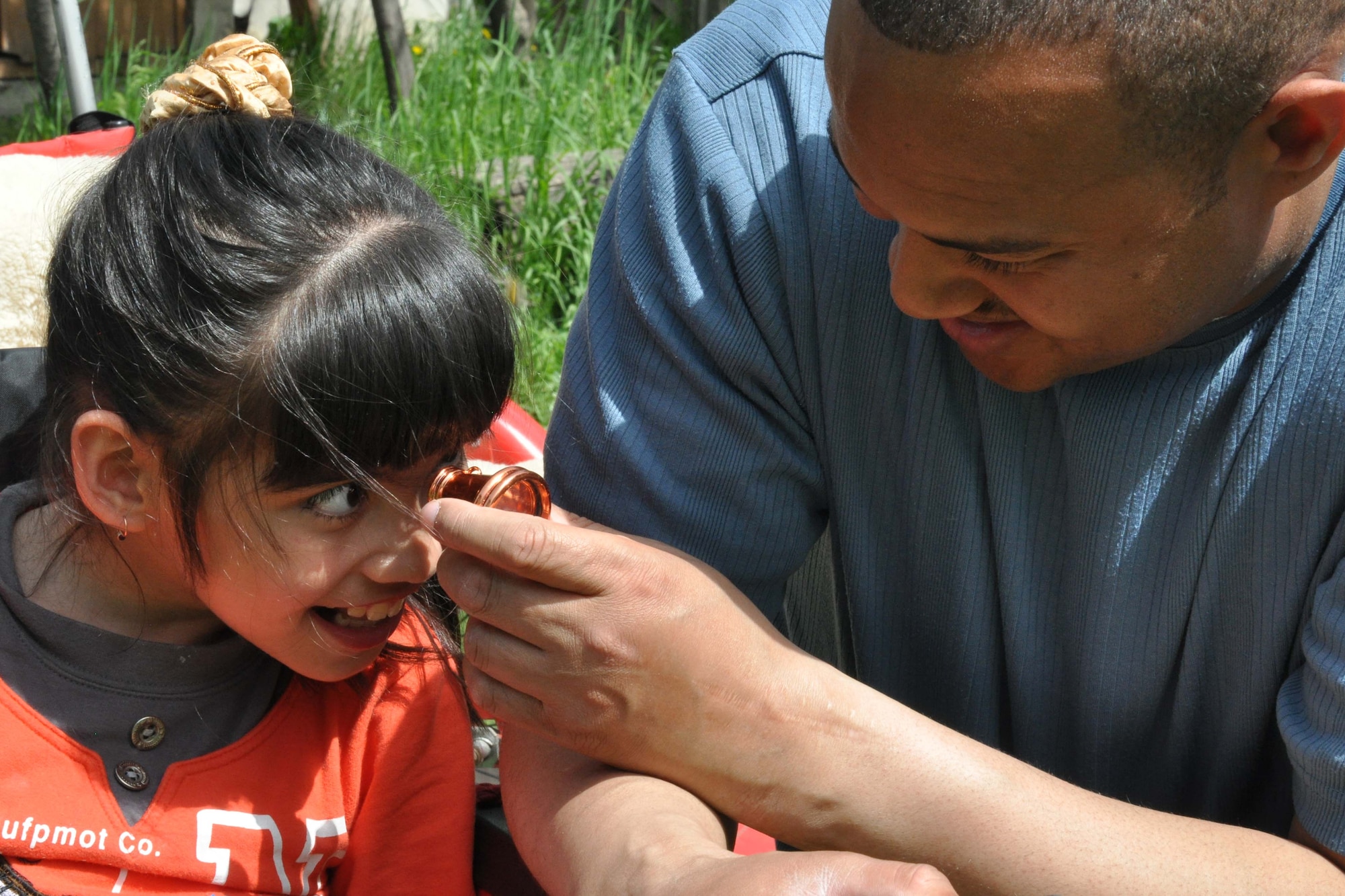 Master Sgt. Anthony Blalock, an Airman from the Transit Center at Manas, Kyrgyzstan, helps a girl look through a kaleidoscope at the Nadjeshda Children's Center April 27, 2010. Nadjeshda is home for 60 children and teenagers who are disabled in different ways. With the help of adults, children there are able to learn to sign, draw, study, work and have fun using various methods of therapy. U.S. Airmen have supported Nadjeshda for the last six years, helping rebuild and repair the facility and spending time with the children. (U.S. Air Force photo/Staff Sgt. Carolyn Viss)