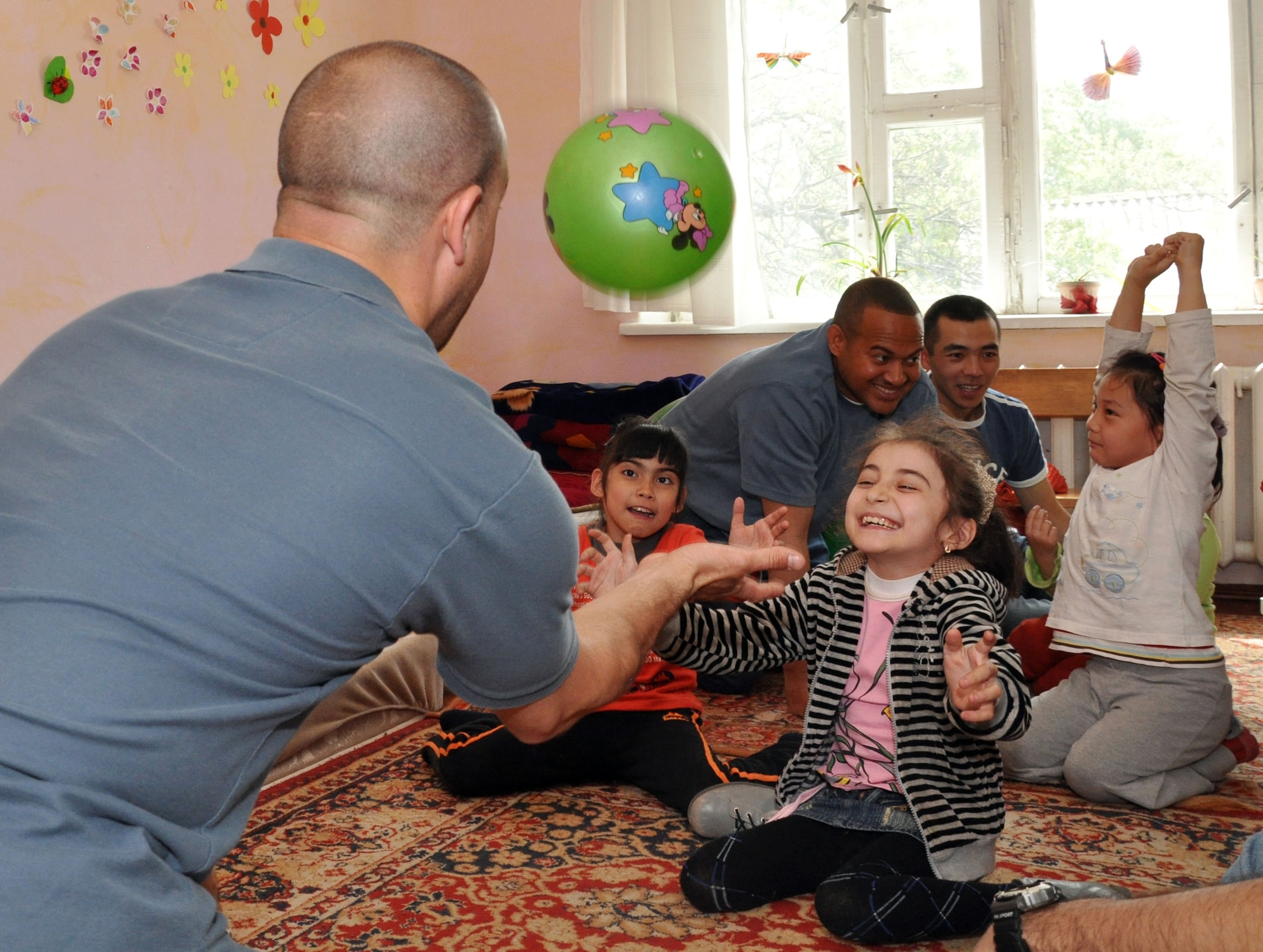 Jeff Villemarette, an Airman from the Transit Center at Manas, Kyrgyzstan, plays with children at the Nadjeshda Children's Center April 27, 2010. Nadjeshda is home for 60 children and teenagers.  With the help of adults, children there are able to learn to sign, draw, study, work and have fun using various methods of therapy. U.S. Airmen have supported Nadjeshda for the last six years, helping rebuild and repair the facility and spending time with the children. (U.S. Air Force photo/Staff Sgt. Carolyn Viss)