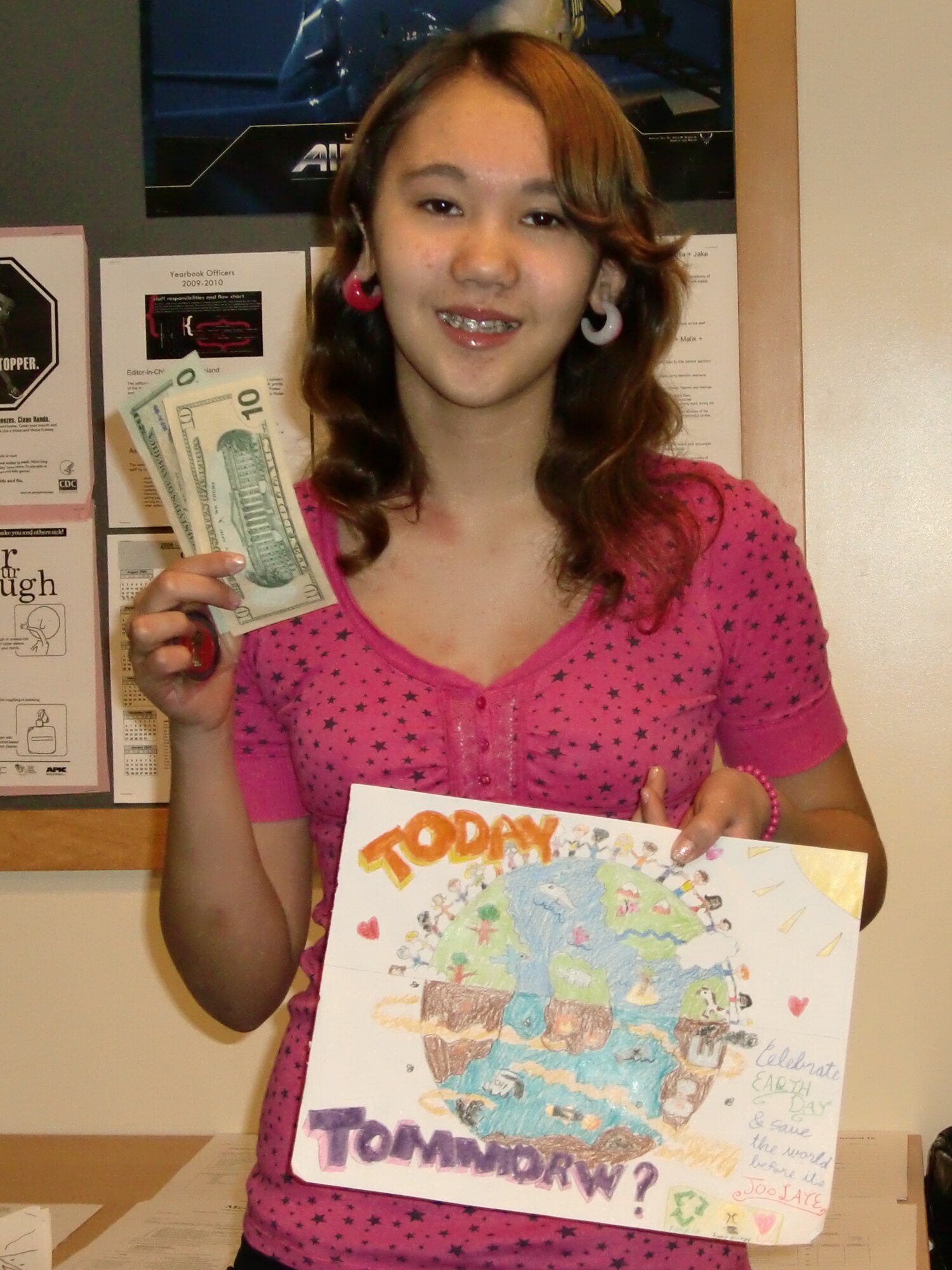 Renea Goddard, a sixth-grade student at Osan Middle School, displays her winning entry in the Earth Day poster contest. The 51st Civil Engineer Squadron sponsored the contest and selected the top three drawings out of all submissions received from base schools by April 19. Each winner received $50 and a 51 CES coin. (Courtesy photo)