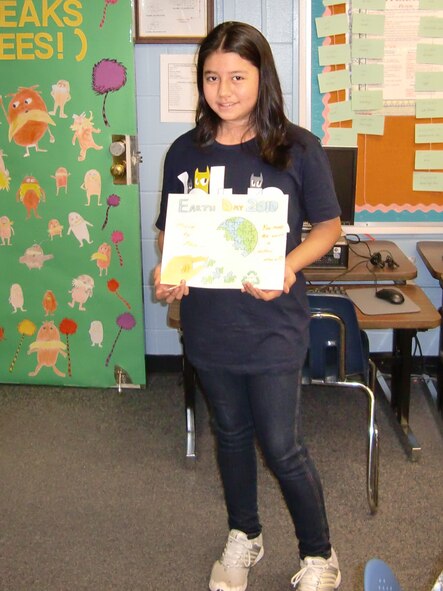 Catherine Hettler, a fourth-grade student at Osan American Elementary School, displays her winning entry in the Earth Day poster contest. The 51st Civil Engineer Squadron sponsored the contest and selected the top three drawings out of all submissions received from base schools by April 19. Each winner received $50 and a 51 CES coin. (Courtesy photo)