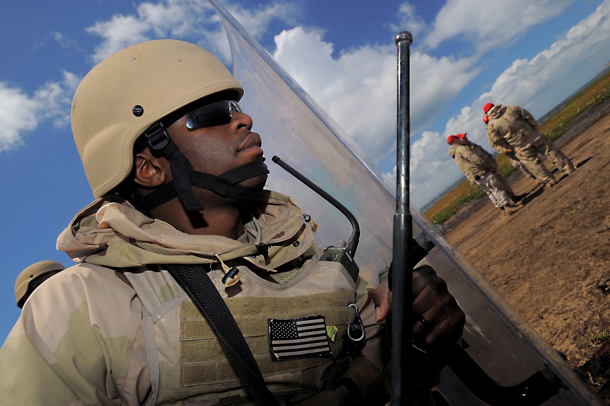 U S Navy Petty Officer 3rd Class Jason Henry Takes Cover Behind A Riot Shield As Training