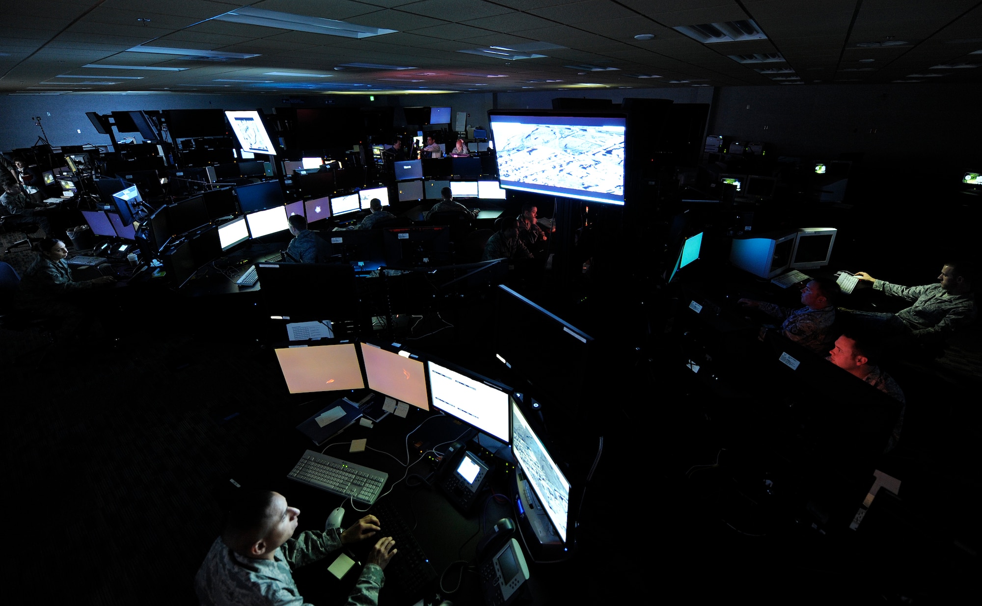 LANGLEY AIR FORCE BASE, Va. – Airmen of the 497th Intelligence, Surveillance and Reconnaissance Group work diligently on the operations floor of the new 497th ISRG building April 21. More than 80 miles of fiber cable are installed throughout the complex, serving as a conduit for the group's intelligence products for deployed servicemembers.  (U.S. Air Force illustration/ Senior Airman Dana Hill)