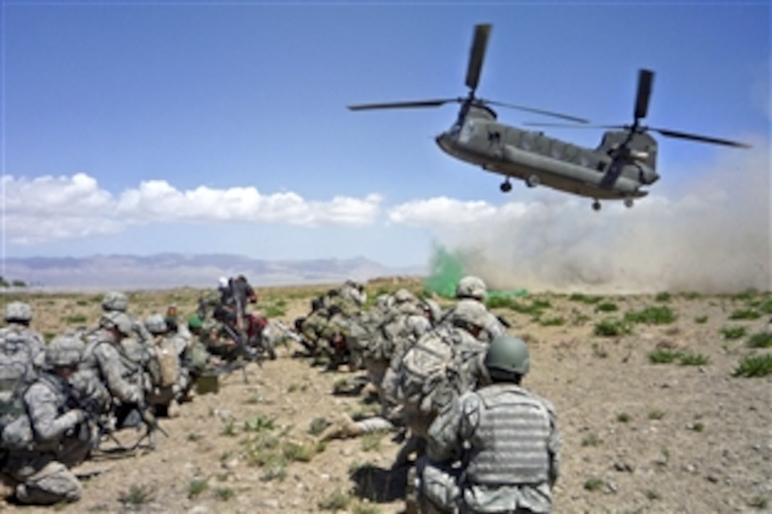 U.S. and Afghan soldiers watch as the CH-47 Chinook helicopter that brought them to the village of Mengal Kheyl in the Zormat district of Afghanistan’s Paktya province, lands after completing an air assault mission, April 22, 2010. The soldiers, who  captured the district’s largest weapons cache in three years are assigned to Company C, 3rd Battalion, 172nd Infantry Regiment, Vermont National Guard.